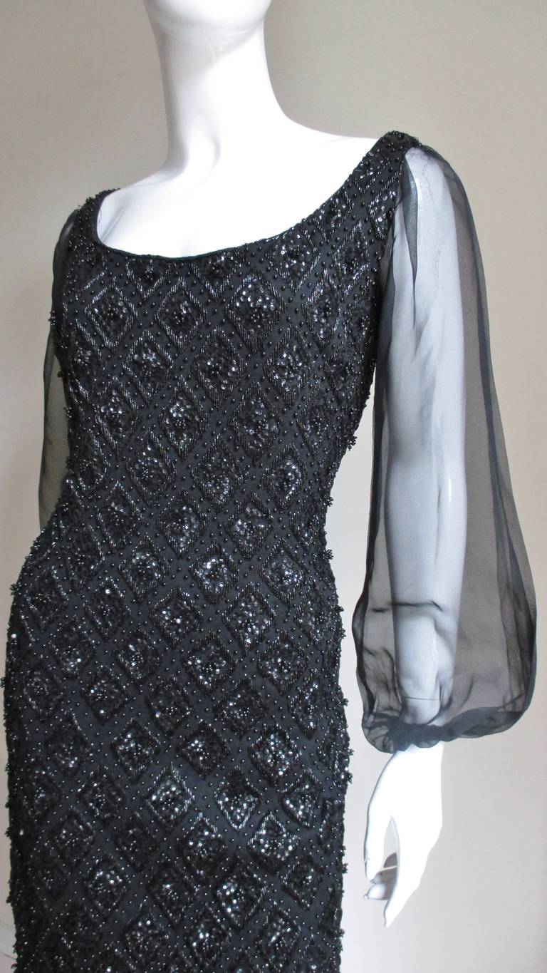 A fabulous black knit beaded Banff dress from Zacks, an upscale 1960s department store in England.  It has a wide scoop neckline and long sheer balloon style sleeves gathering at the wrists. The beading pattern throughout the body of the dress is