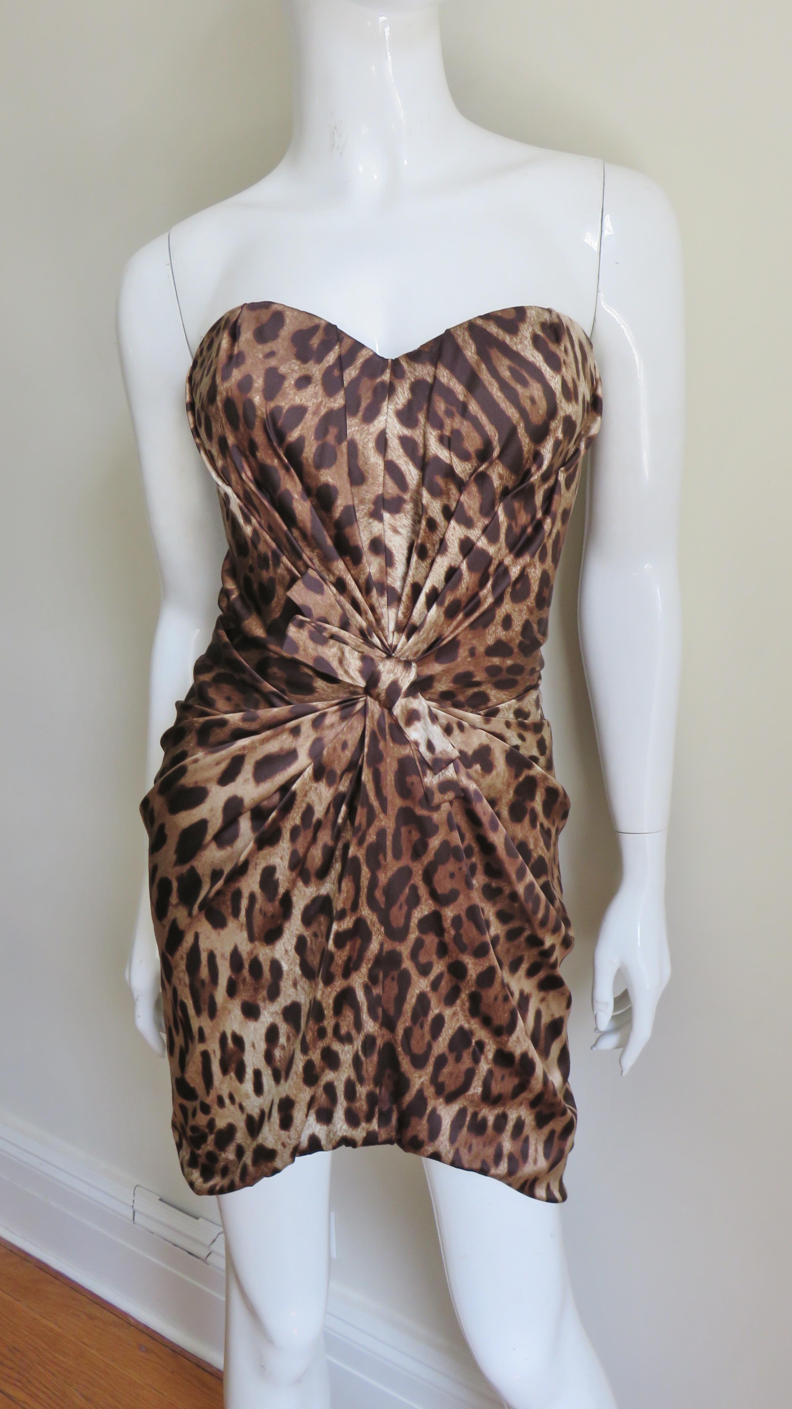 A stunning fine silk leopard print bustier dress from Dolce and Gabbana. Ruching emanating from the center front creates a flattering cinched waist, in contrast the back is unadorned. The dress has a back zipper, is fully lined in silk and the