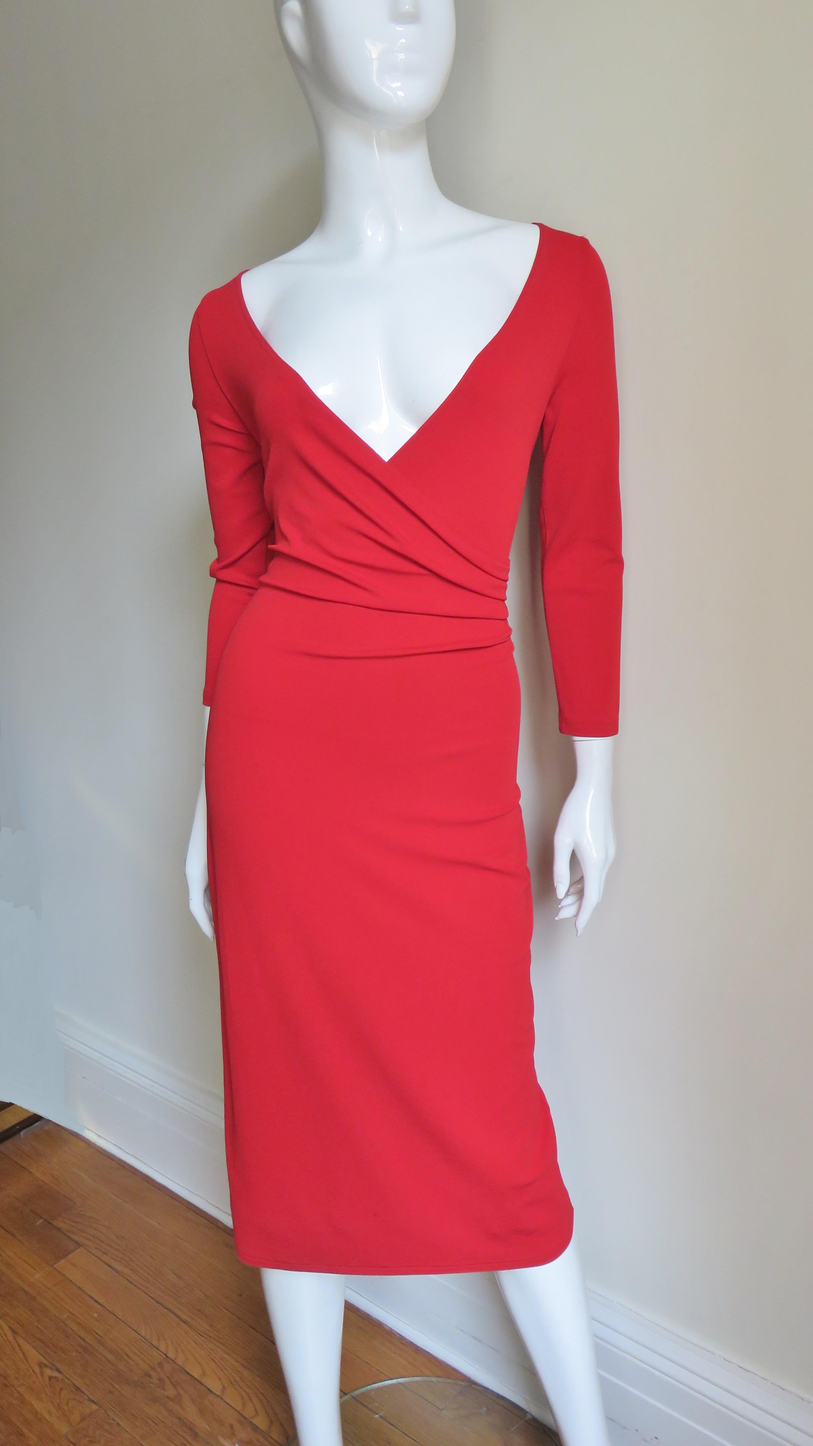 A fabulous red jersey dress from Celine.  It has a wide V neckline, 3/4  length sleeves and a wrapped ruched bodice. The dress is semi fitted through to the hips then falls straight to the hemline. It has a matching red back zipper.
Fits sizes