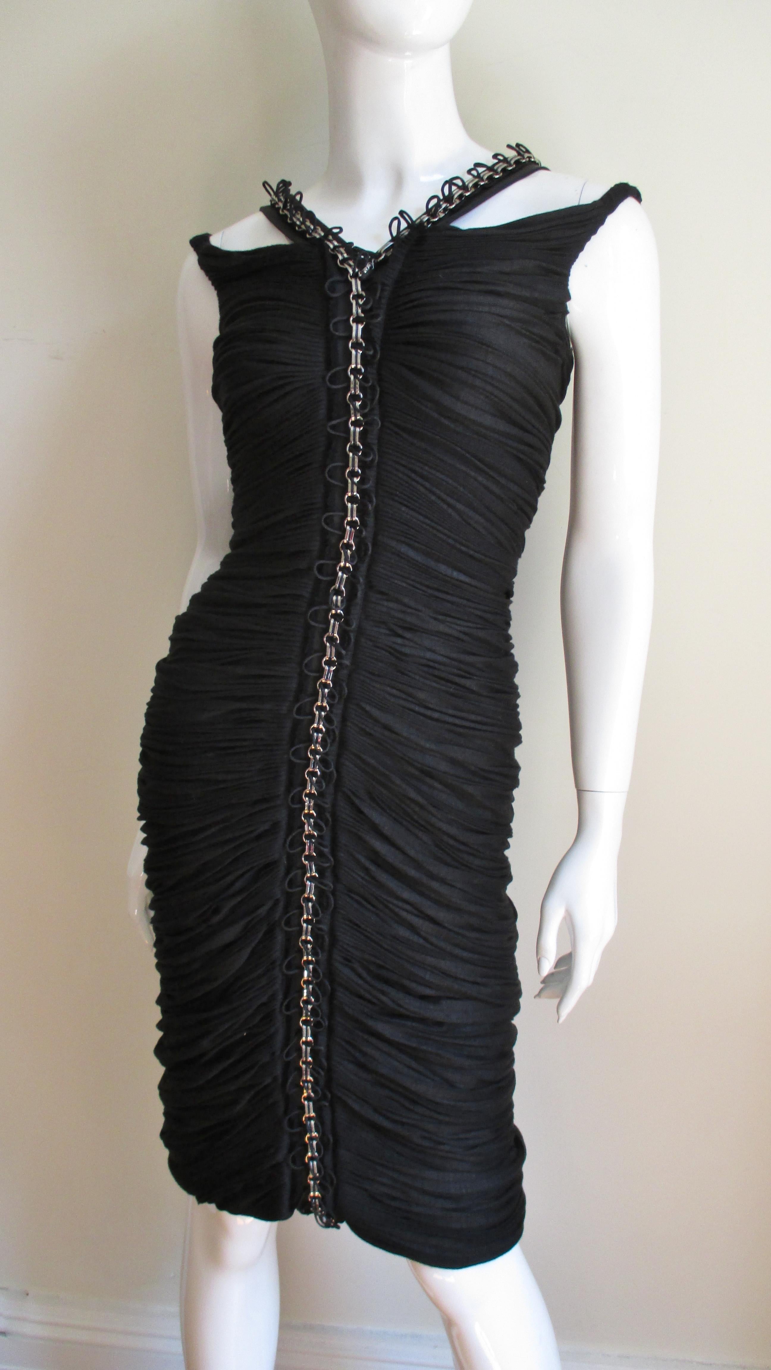 A gorgeous fine black silk knit dress from Anne Klein. The dress is ruched horizontally it's entire length front and back and has fine silk cord interwoven through silver chain accentuating the dress's center front and back. The detail and work is