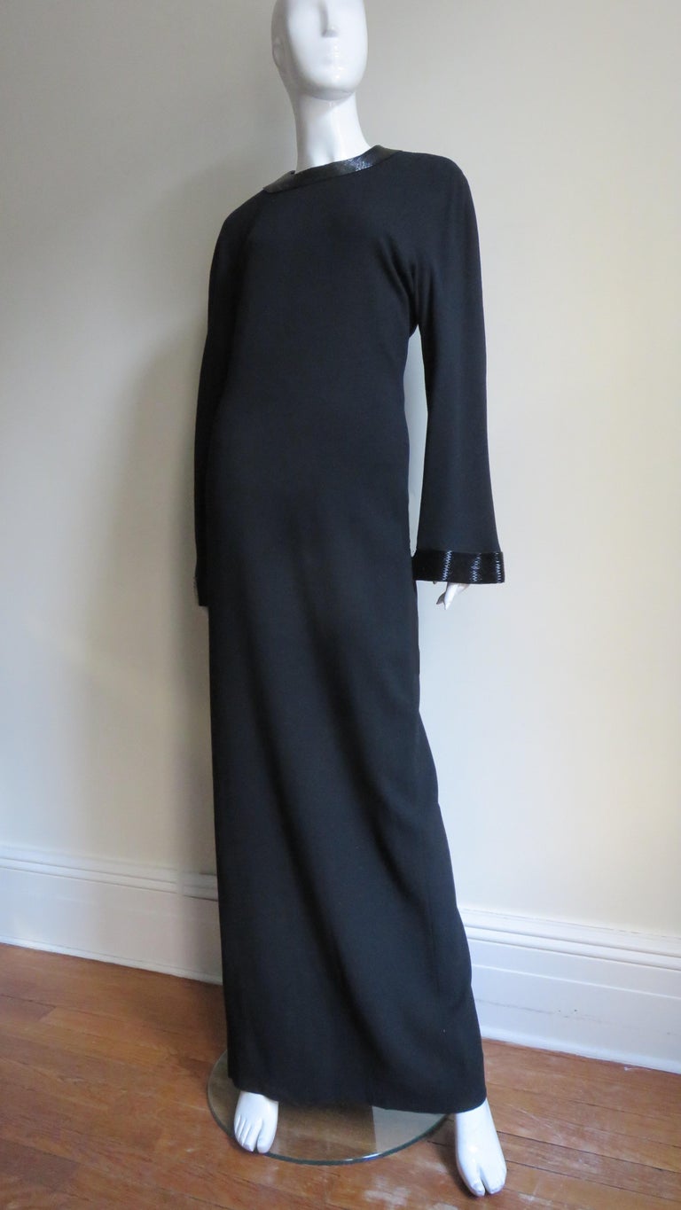 A sophisticated simple black wool column maxi dress by Anne Klein. It has a crew neckline and long bell sleeves both finished with 2
