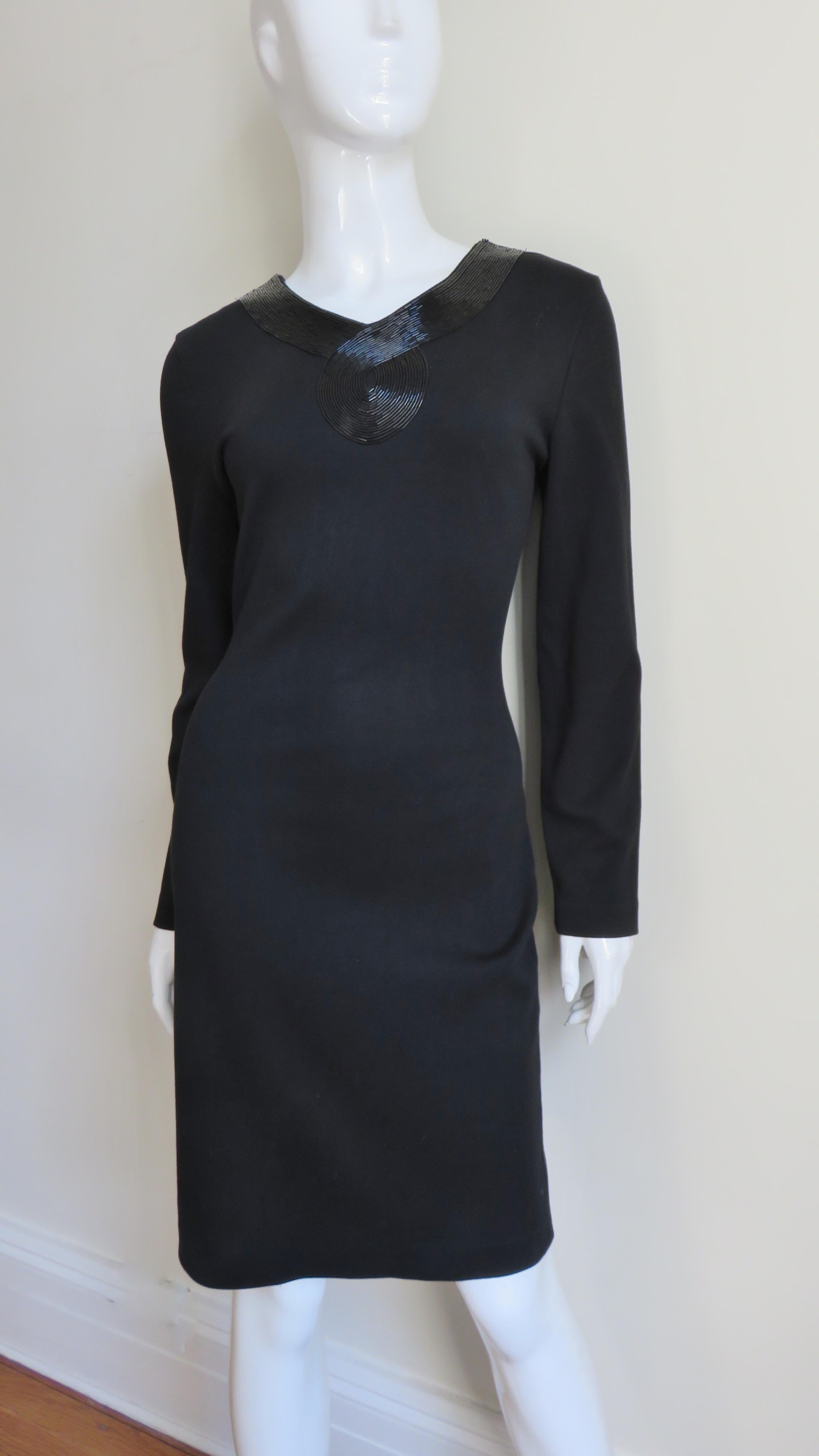 A beautiful black jersey dress simply cut, semi fitted with a deep V back and long sleeves.  What sets it apart is the row upon row of tubular black glass beads around the neck and back with a circular swirl at the base of the back and front