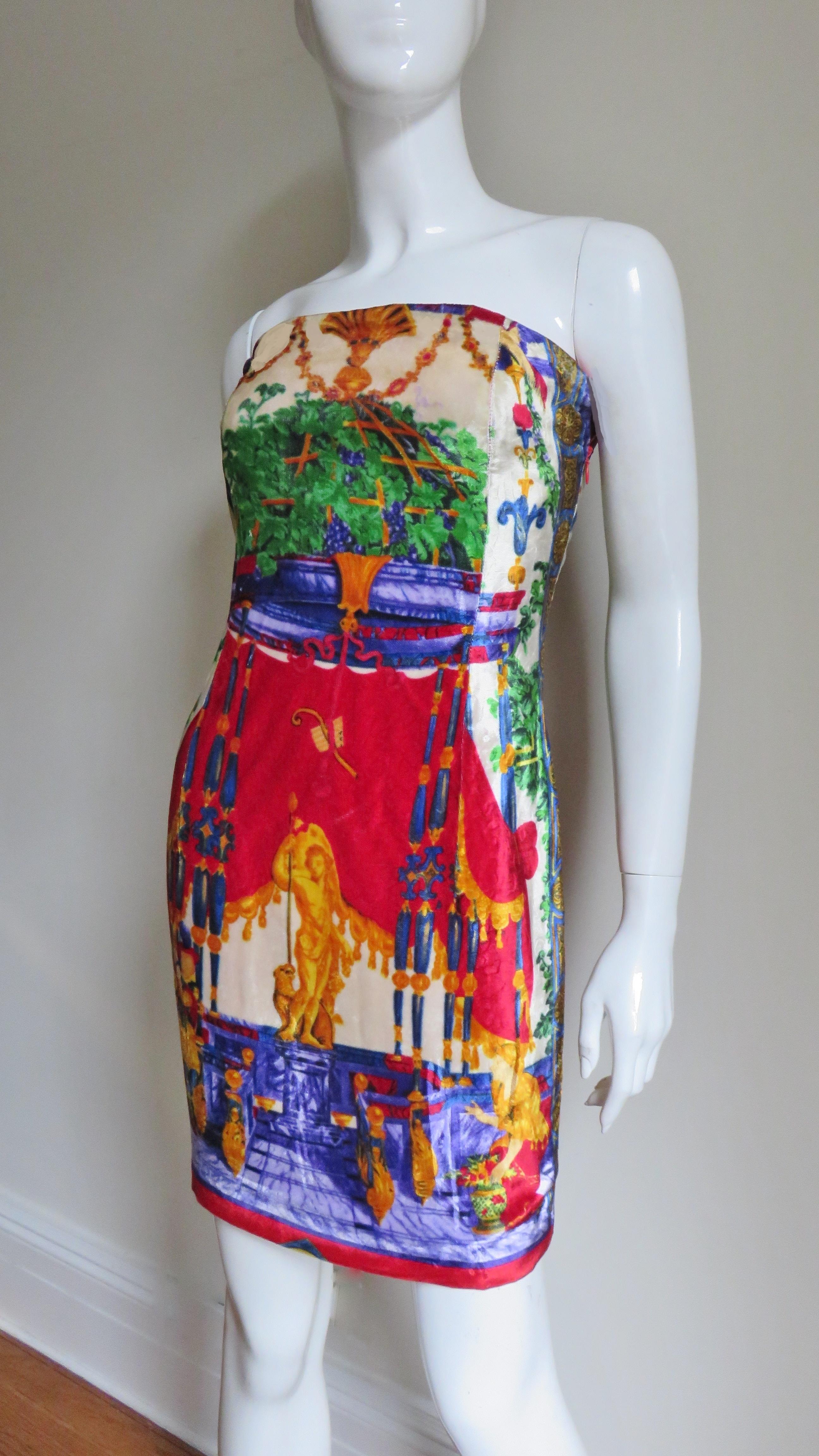 Un bellissimo abito senza spalline in velluto di seta dai colori vivaci con un'elaborata stampa di flora, fauna, fanciulle, statue e re per cui Gianni Versace era famoso e che sta diventando sempre più rara e difficile da trovare nelle prime