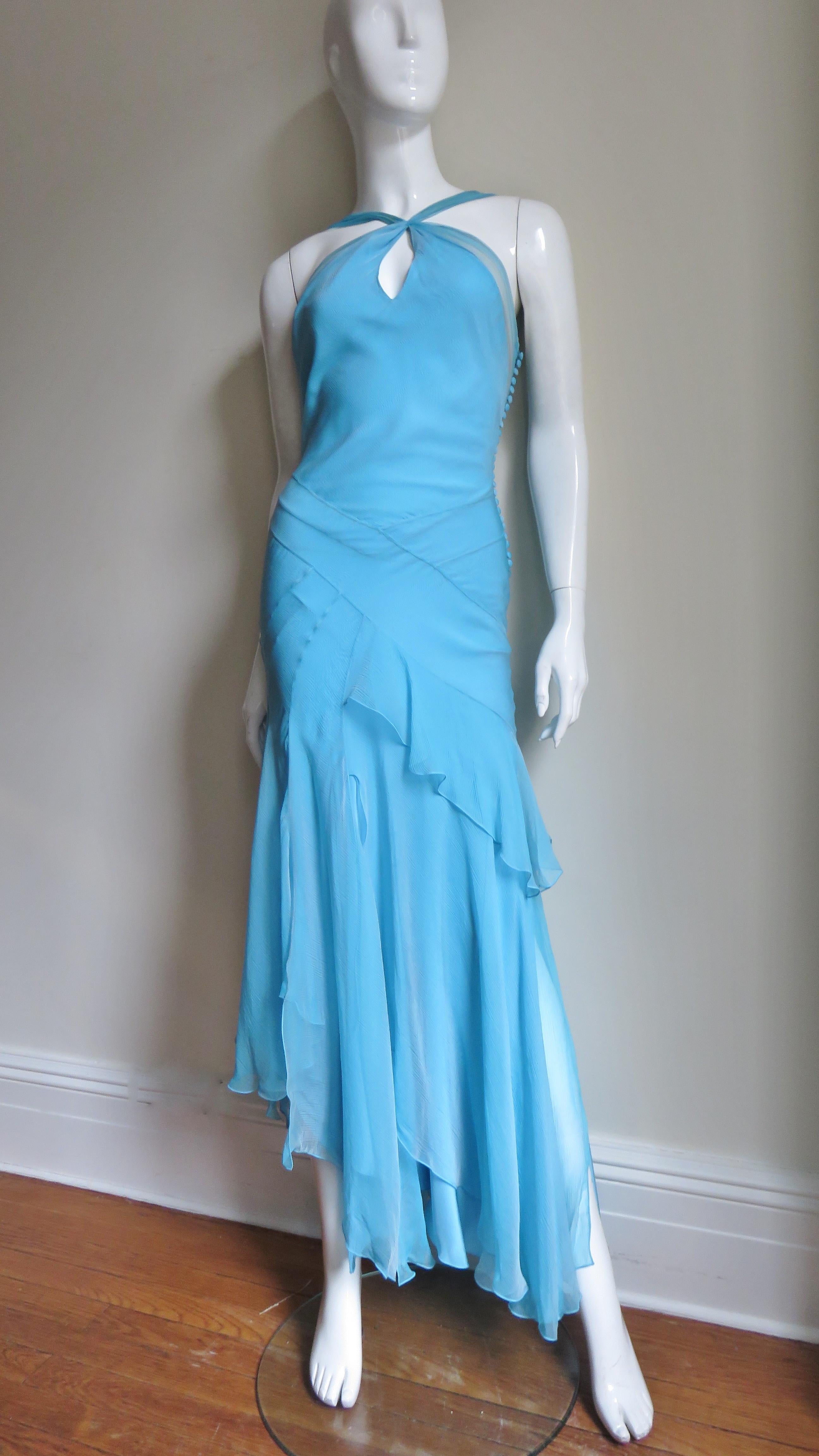 A gorgeous silk gown in a stunning shade of blue by John Galliano for Christian Dior.  It has crossing straps at the chest with a keyhole under it which attach to the mid back.  There is sheer panel along the bodice sides and back.  It has a