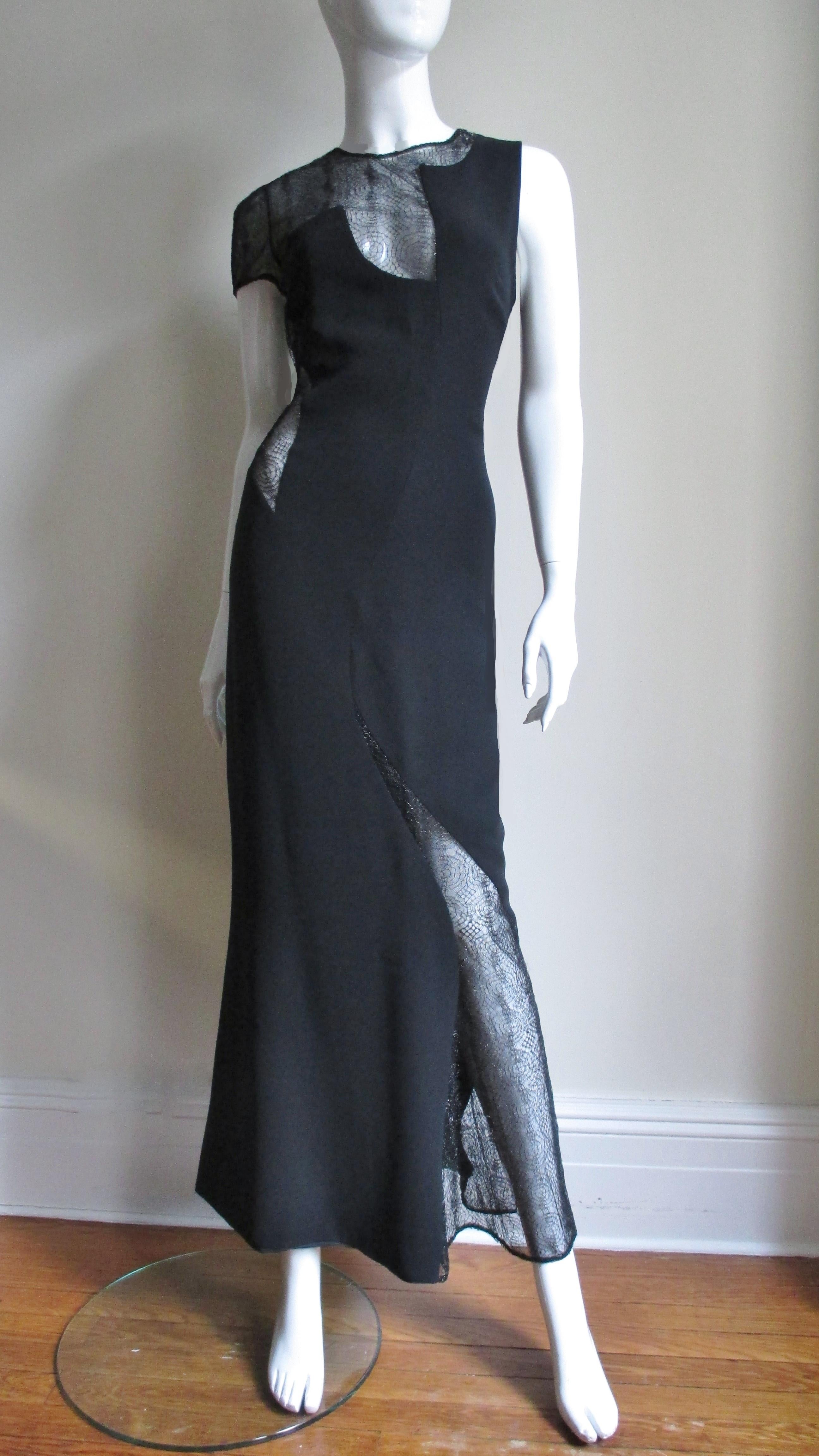 A gorgeous Gianni Versace Couture full length black silk and lace dress.  it has a scoop back, one short sleeve and is asymmetrically cut with web pattern lace covered cut outs at one side waist, leg, sleeve and the décolletage. The dress skims the