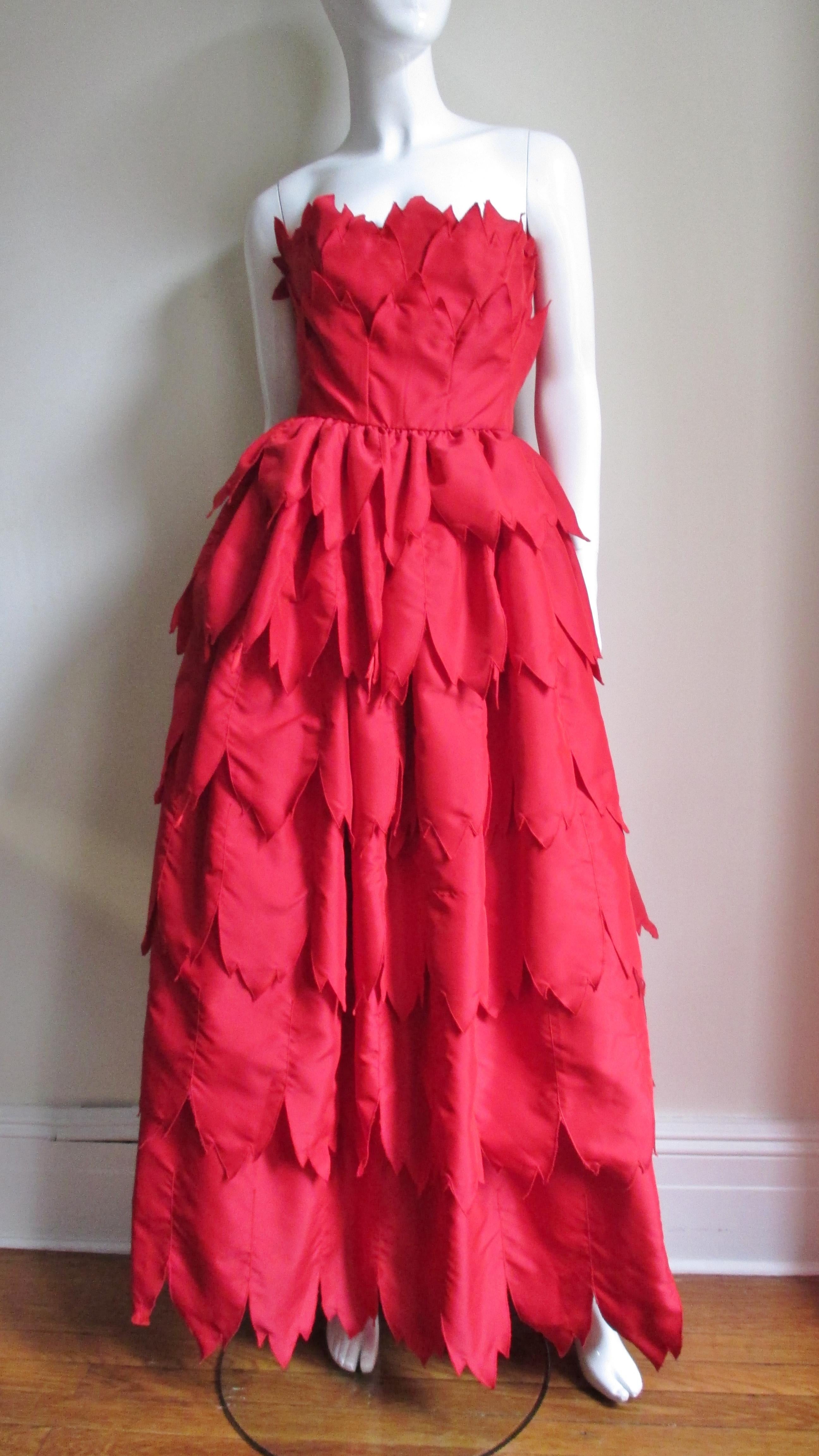 From acclaimed designer William Travilla a stunning gown comprised of layers of pointed edge red silk. He is famous for among other things creating Marilyn Monroe's iconic subway vent dress for the movie The Seven Year Itch. This dress is strapless