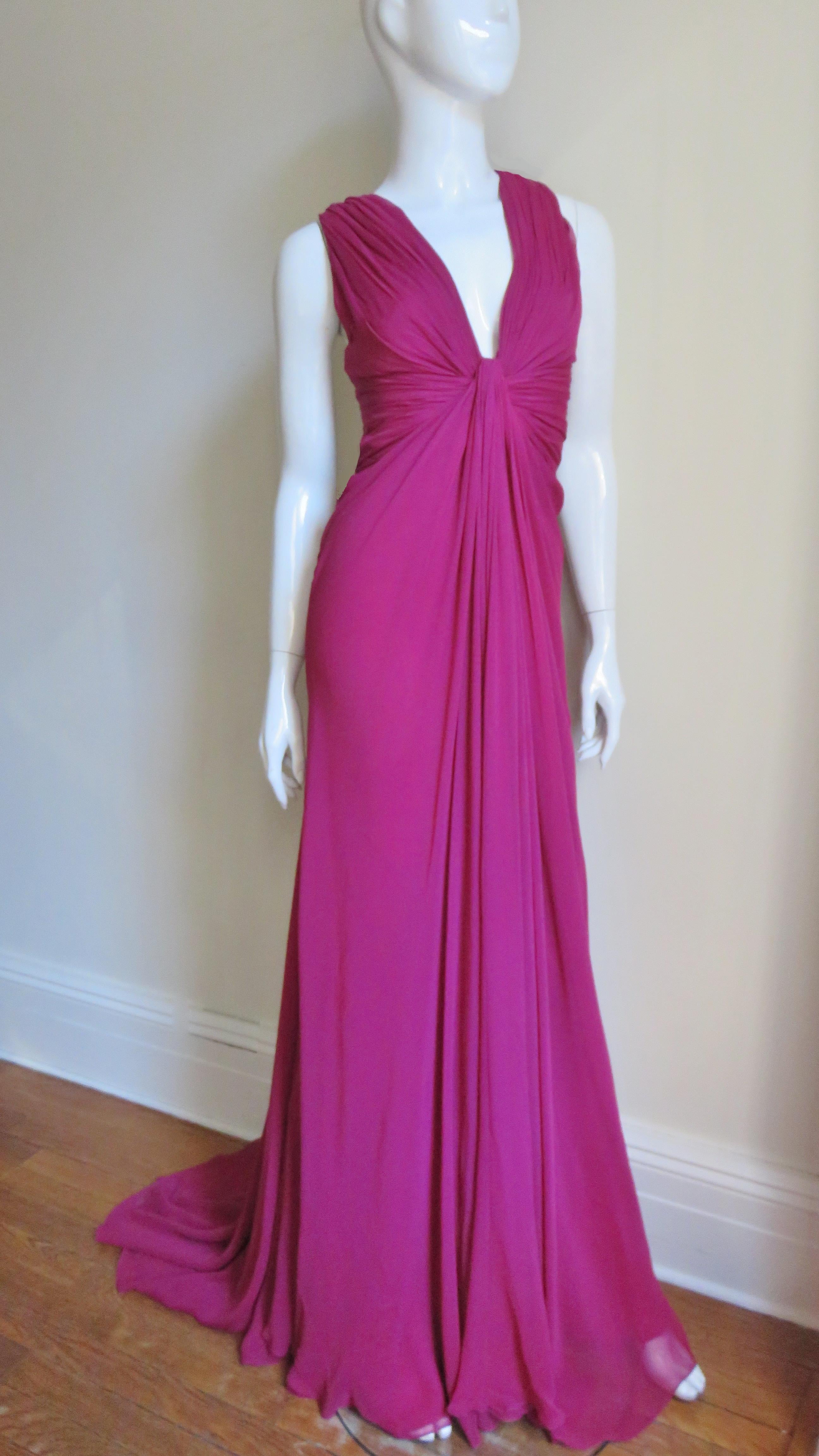 A gorgeous flattering deep pink silk gown from J. Mendel.  It has a ruched plunging neckline and sides all meeting at the center front waist- very flattering. The back is bare to the waist except for straps crossing at the upper back. The skirt has
