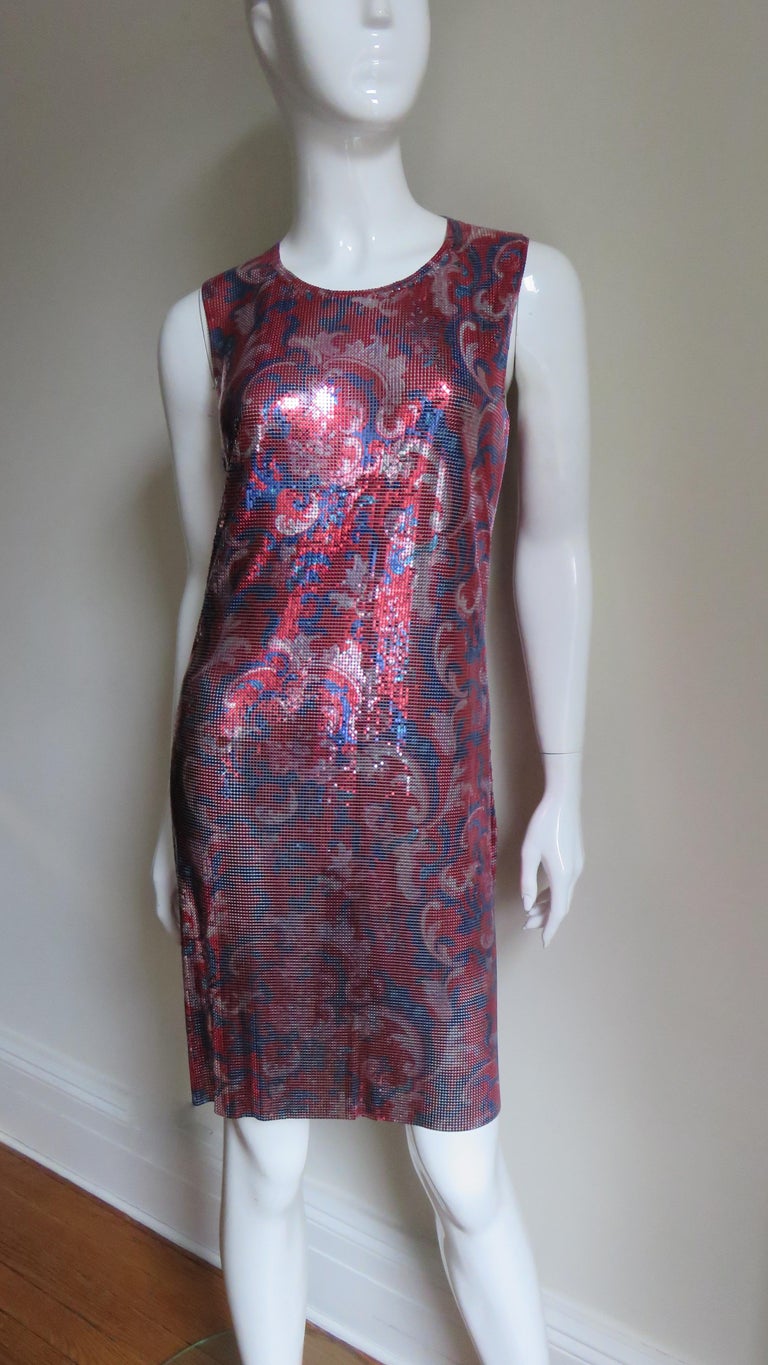 An incredible metal mesh, chain mail dress in a beautiful red, blue and silver abstract print from Paco Rabanne.  It is a sleeveless with a rounded neckline.  The dress is unlined and has 3 silver metal Rabanne stamped snaps at the back of the neck