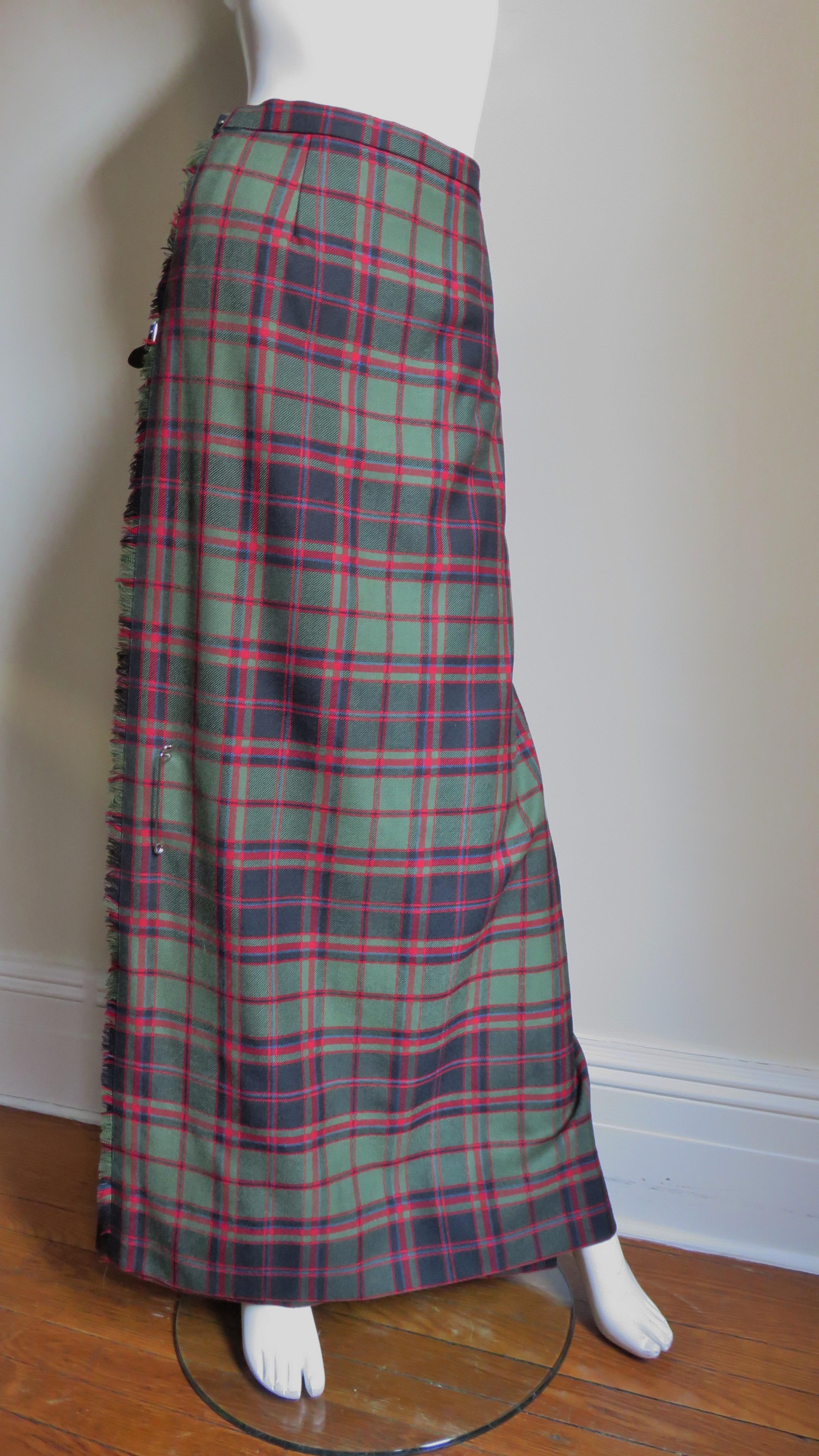 A fabulous plaid wool maxi kilt in red, green and black tartan. It is a traditional kilt wrapping in the front with adjustable leather straps with buckles at the side waist and hip, a front skirt pin and a pleated back.  
Fits size Small,