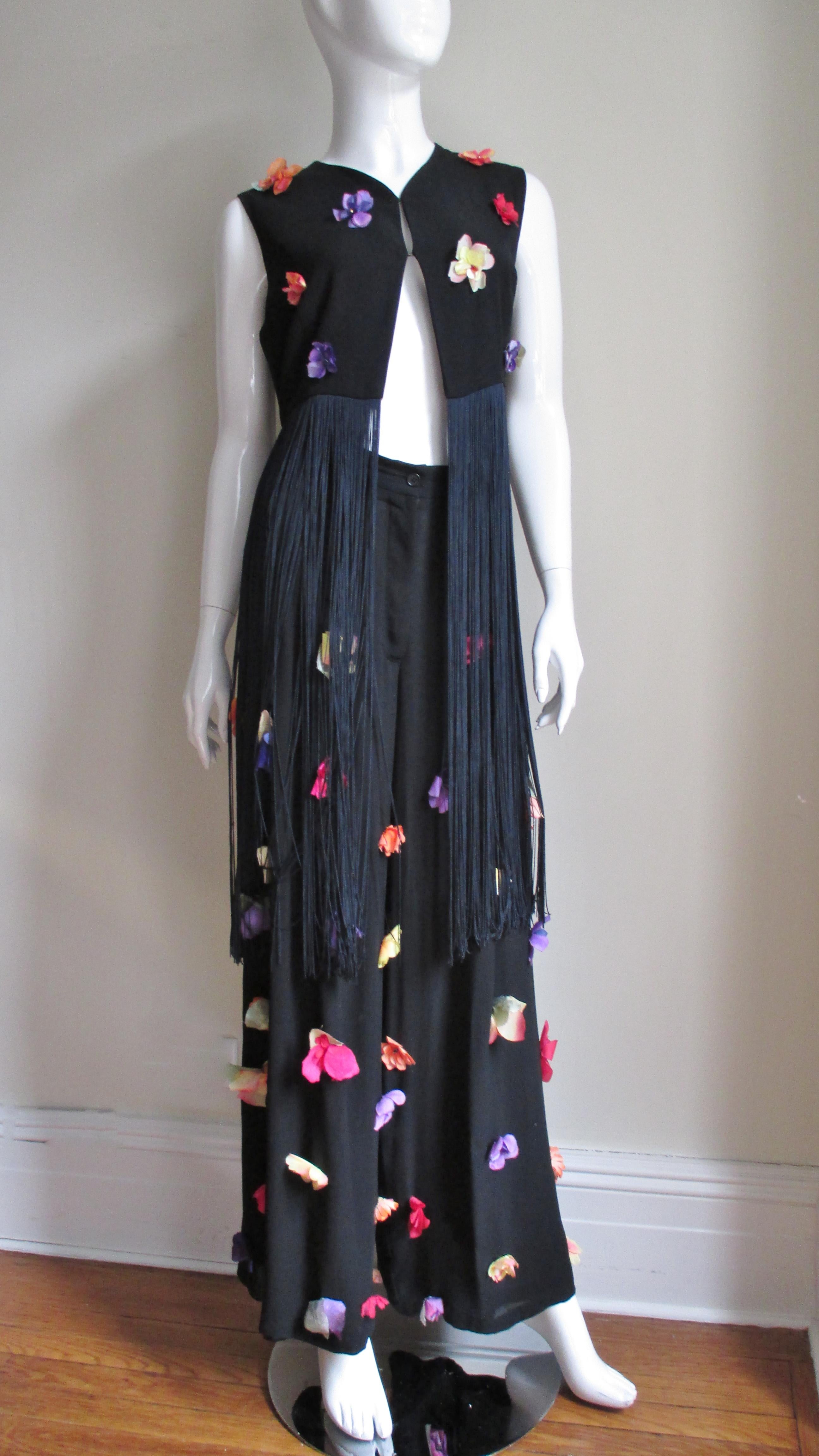 Un superbe ensemble pantalon noir et haut/veste de Dolce & Gabbana recouvert de fleurs en soie de différentes variétés et couleurs. Le haut à col en V est de la longueur d'un ventre:: avec une frange de soie fine de deux pieds qui pend à l'ourlet et
