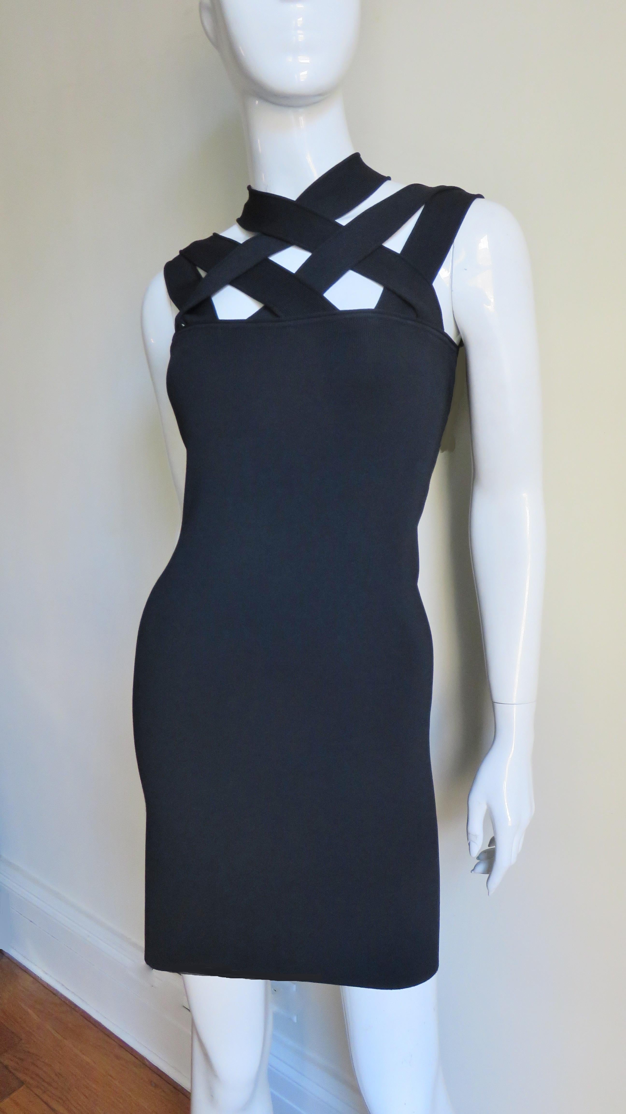 A great black bandage style dress from Givenchy.  It is fitted with criss crossing straps over the shoulders front and back.  The dress is unlined and goes on over the head.   
Fits sizes Extra Small, Small, Medium.

Bust  33-36