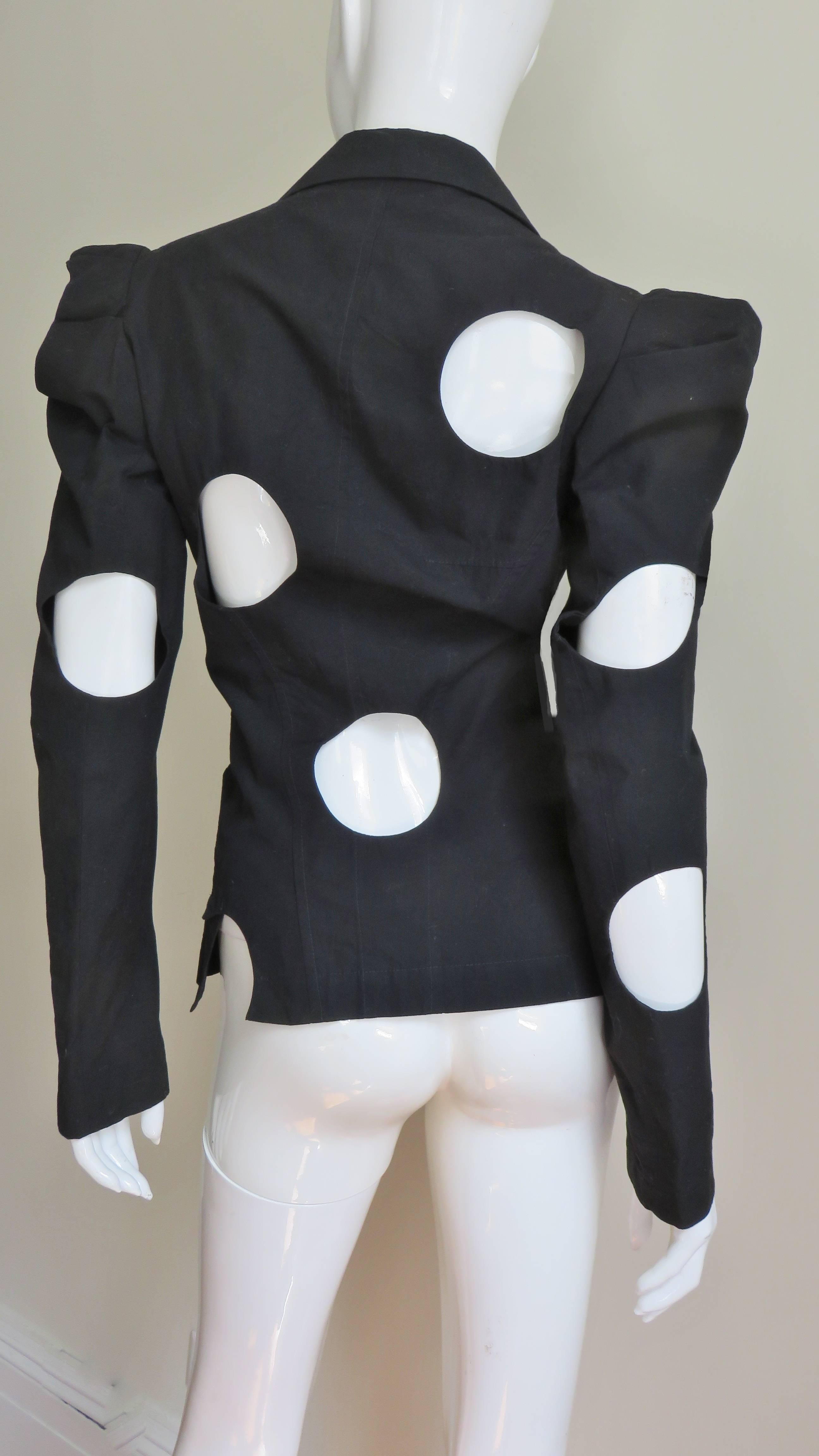 Une fabuleuse veste en coton noir signée Yohji Yamamoto.  Il présente des revers en pointe, une fermeture à deux boutons sur le devant et de remarquables découpes en cercle placées de manière aléatoire.  Chaque cercle est magnifiquement