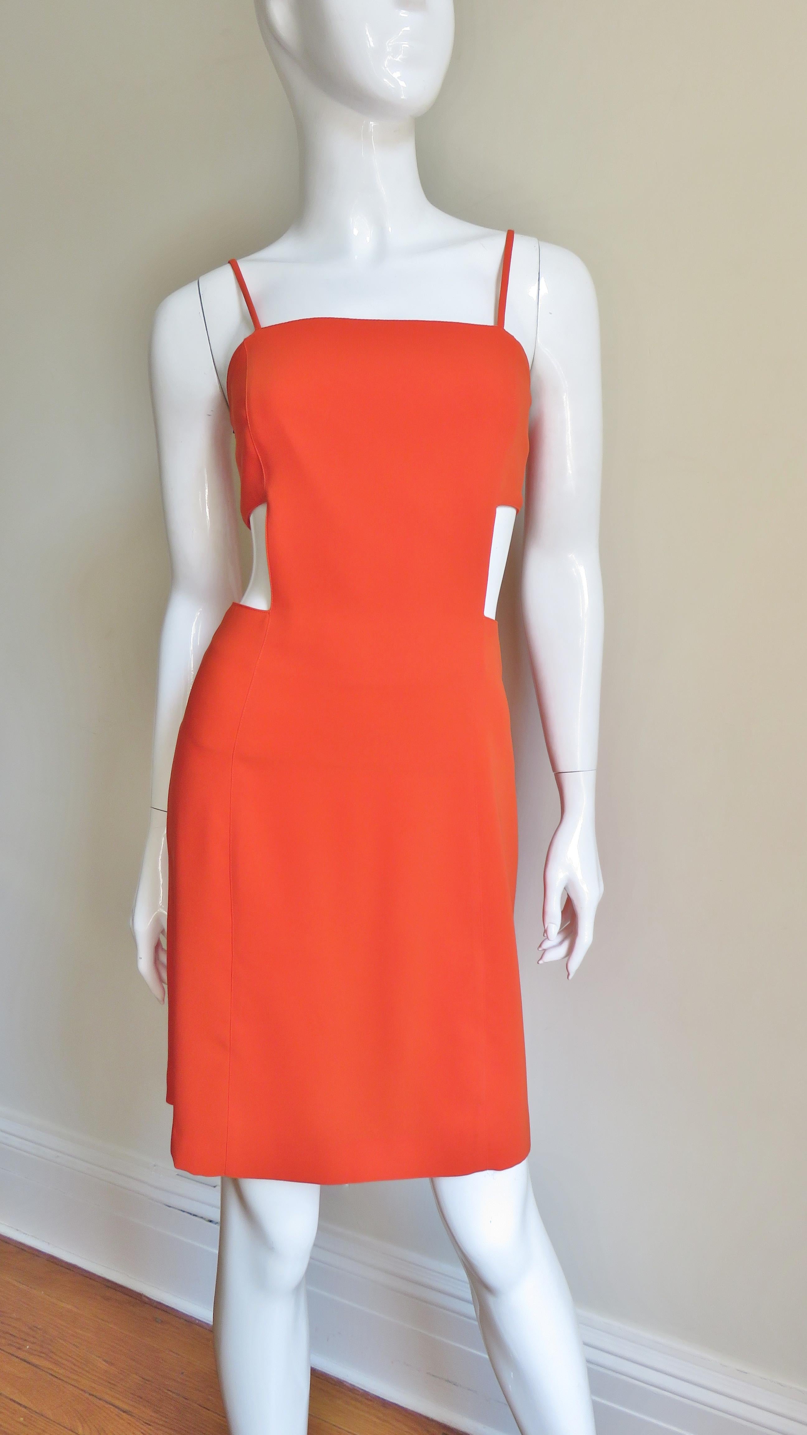 A fabulous orange dress from Thierry Mugler.  It is semi fitted with princess seaming, spaghetti straps and fabulous square cutouts at both sides of the waist.  It is lined in matching orange and has matching back zipper.
Fits size Extra Small,