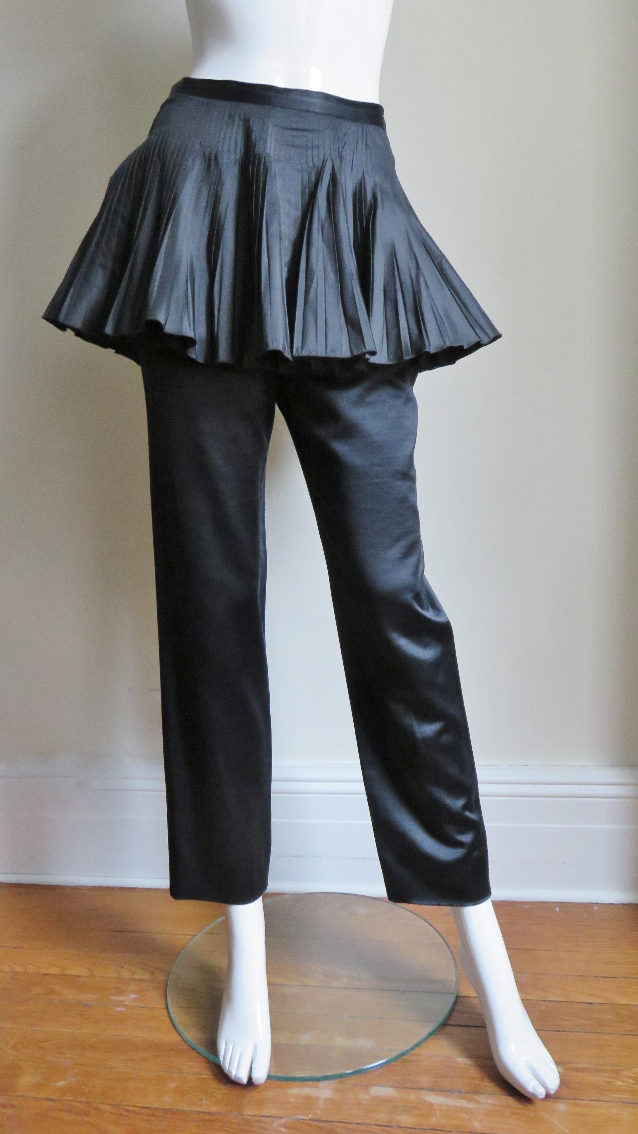 Fabulous pants in rich black silk from Valentino. They have straight legs under a finely pleated double layered silk peplum attached at the waistband.  The pants have a side zipper, side seam pockets and the peplum closes with silk covered