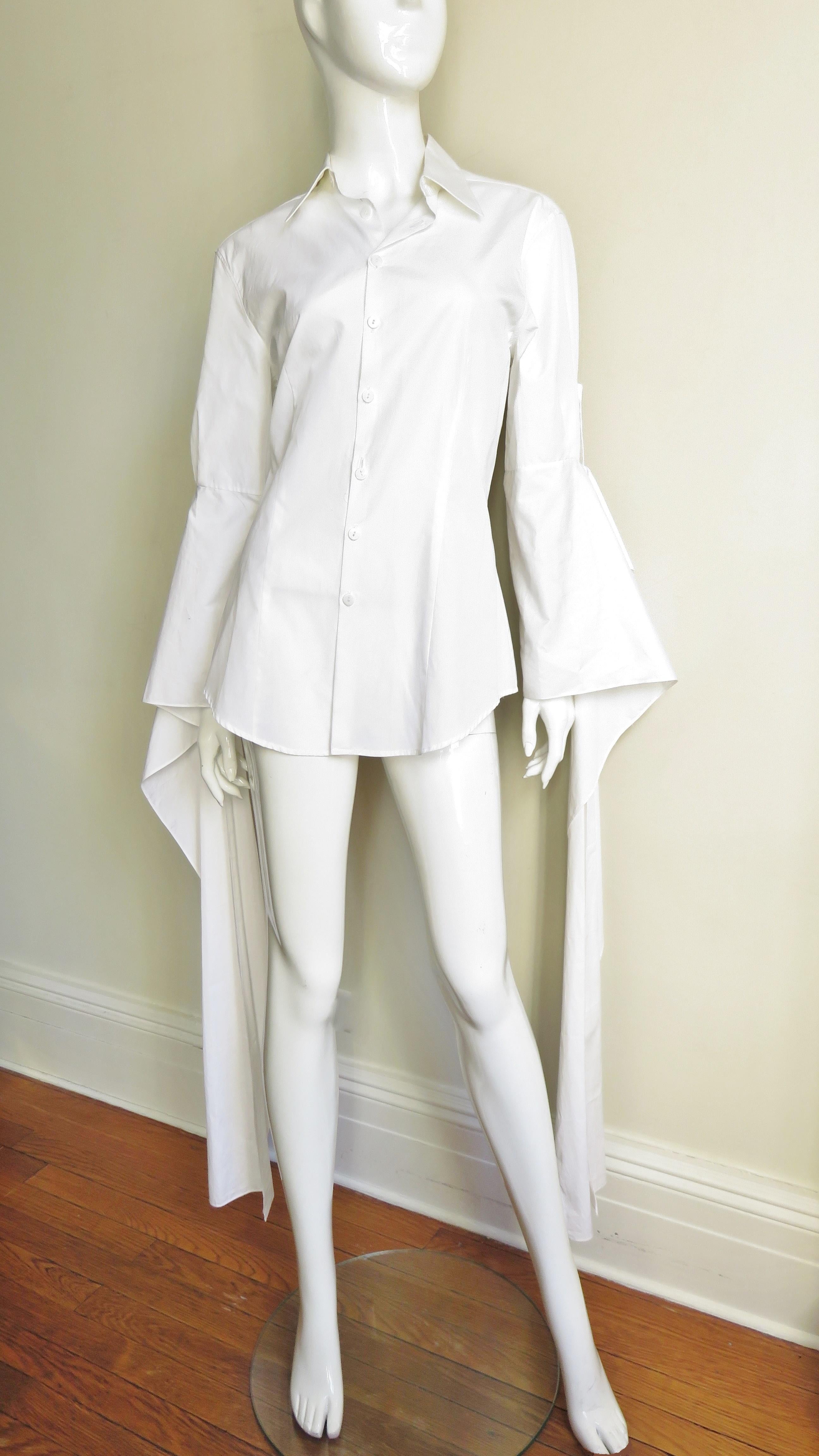 A fabulous white cotton shirt from Jean Paul Gaultier.  It has a shirt collar, mother of pearl buttons up front and long draping cuffs. The princess seaming makes for a great fit. Fabulous!  
Fits sizes Small, Medium.

Bust  40