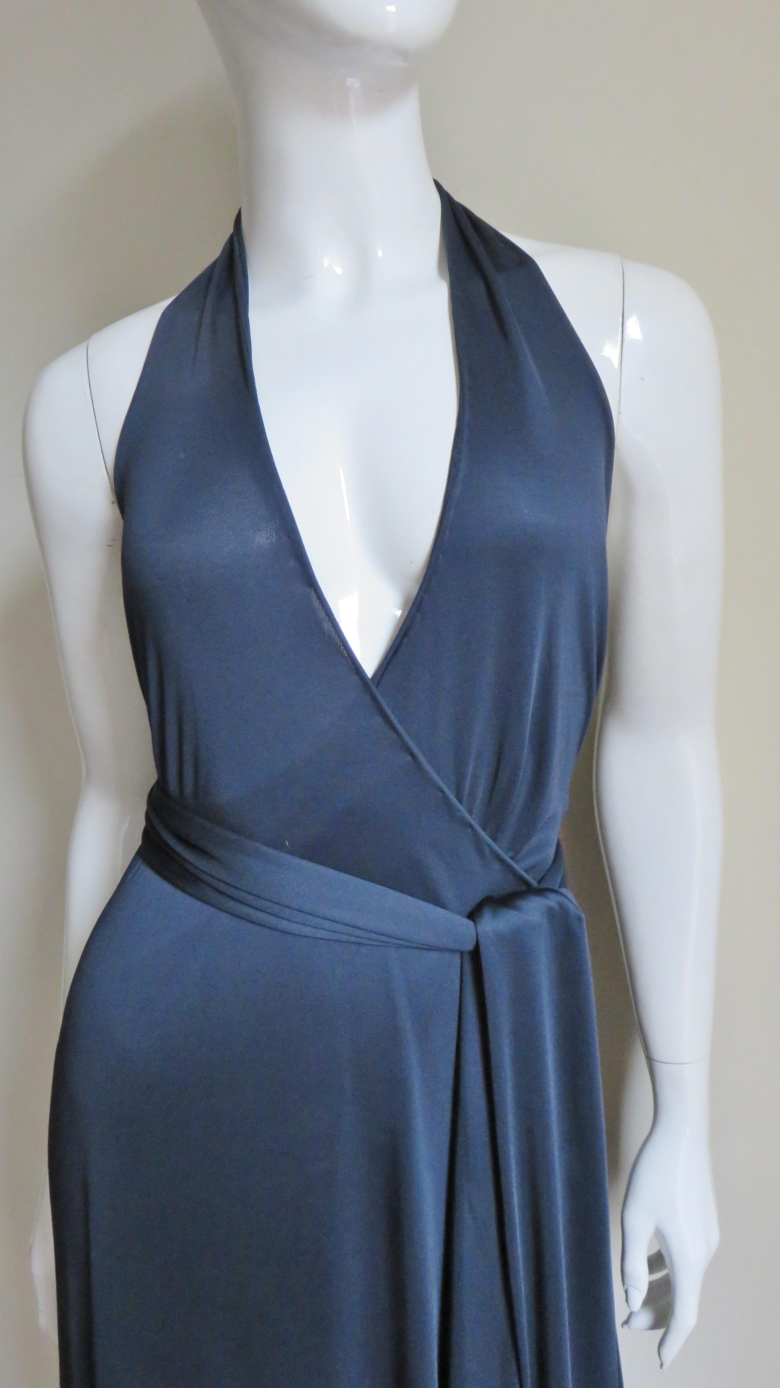 A fabulous wrap dress in a fine navy blue silk jersey from Tom Ford for Gucci. It has a halter neck wrapping and buttoning at the waist and comes with a matching long tie belt.  The skirt has a side slit and a small train in the back. The dress has