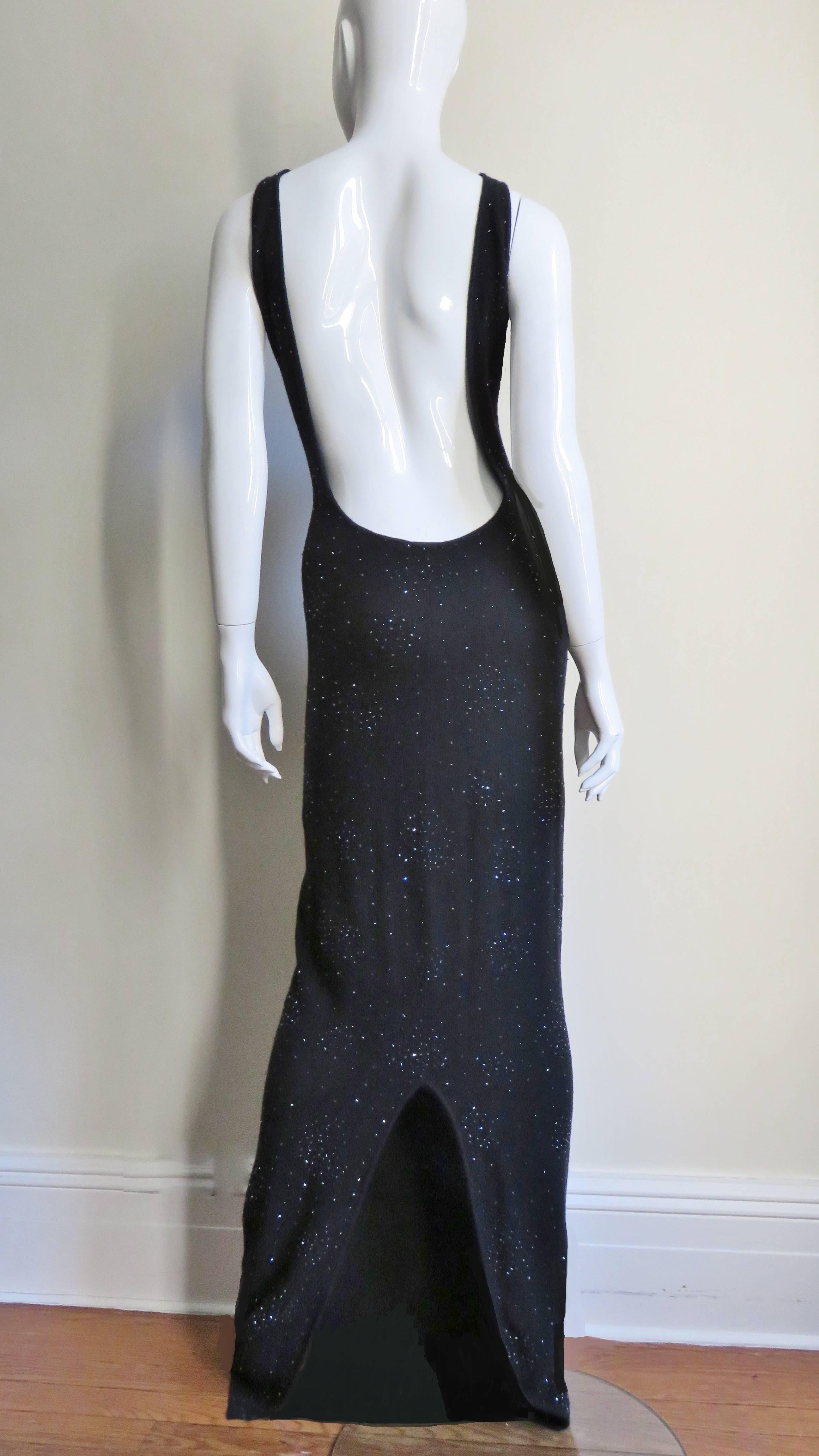 A simple but stunning maxi dress from Halston in charcoal grey soft cashmere knit.  It is fitted through the body with a deep plunging back to below the waist.  It is covered with a smattering of black seed and tubular glass beads which catch the