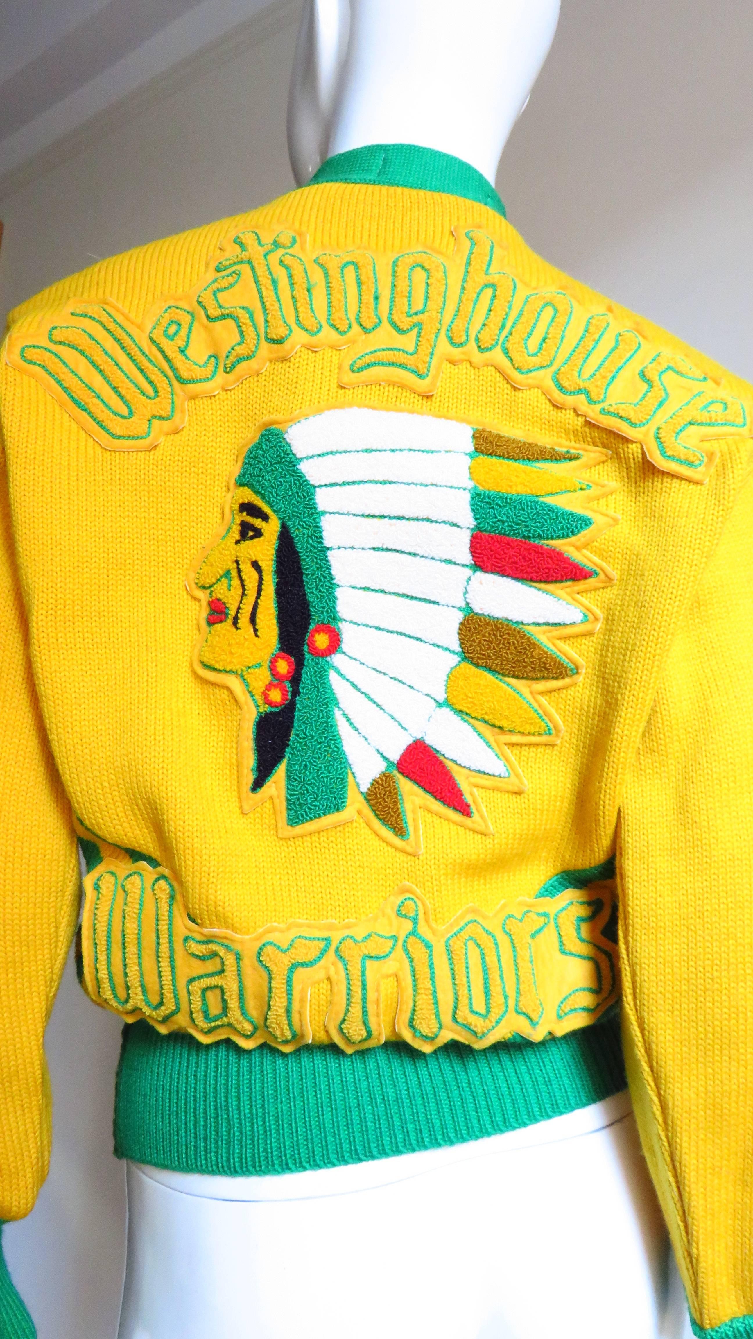 This is a unique wool team sports sweater made by Logan. It is golden yellow with green trim on the V neck, cuffs and waist.  The back is detailed with an applique of the team name 'Westinghouse Warriors' and a colorful Native American image.  The