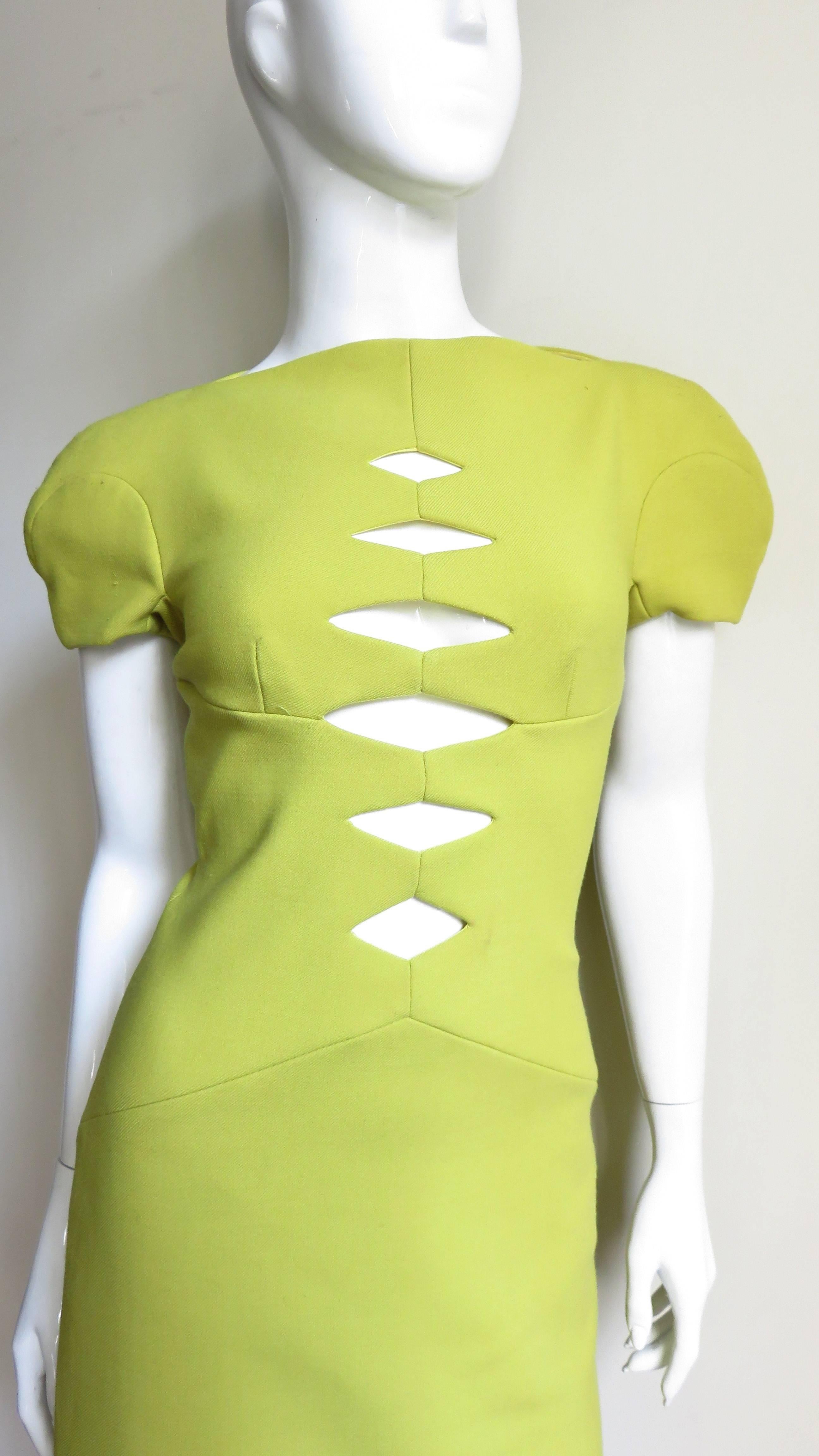 A fabulous little dress in lemon lime light weight wool from the Versus line of Versace.  It has a bateau neckline and defined pieced cap sleeves created with seaming.  The bodice has a subtle V seam under the bust and an inverted V at the hips. 