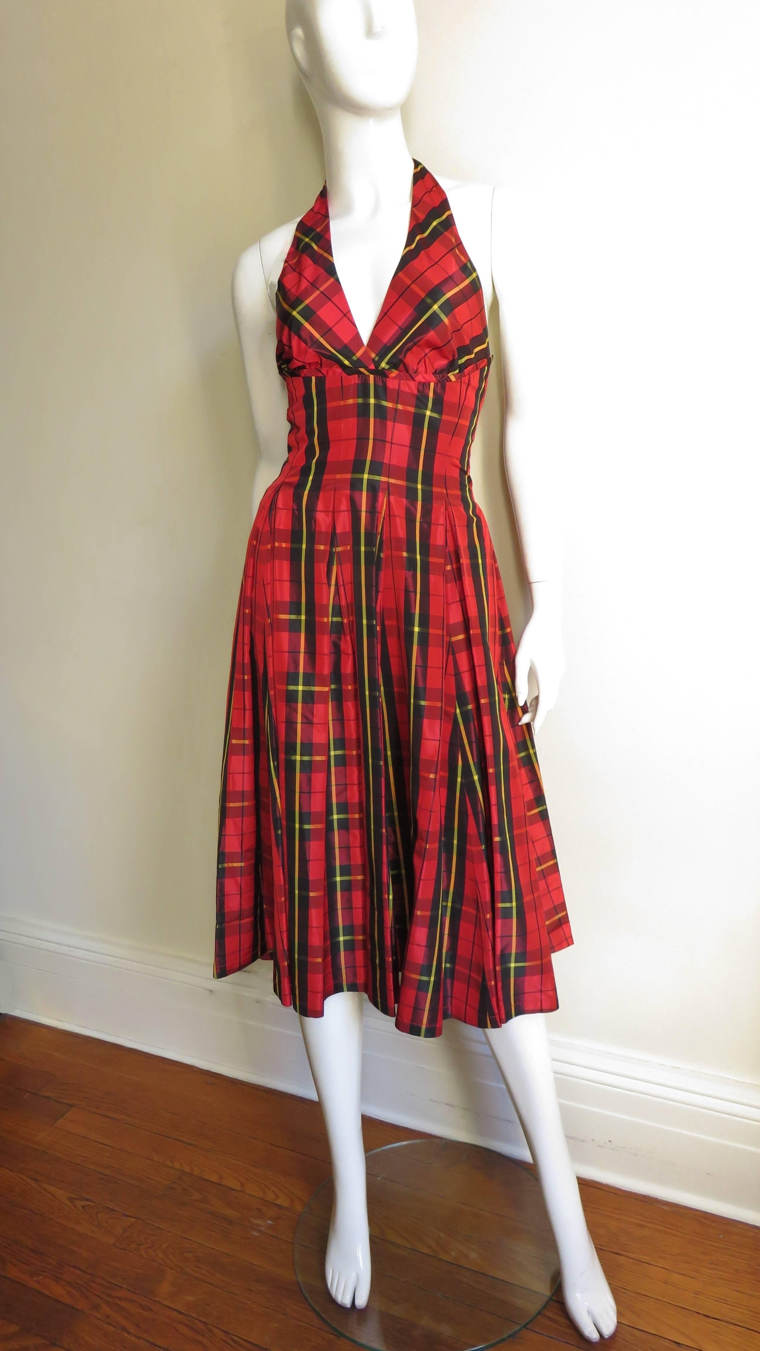A great red, black and yellow taffeta plaid dress from Moschino.  It is halter style with a tucked fitted waist and box pleats that release just below the waist to a full skirt.  The is 1/2