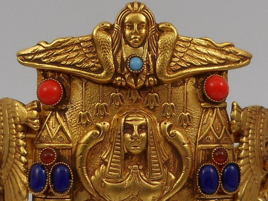 Amazing!  Askew London signed hinged Cuff Bracelet, featuring Antiqued Gilt Brass designs depicting Cleopatra, Falcons and Pharaoh decorated with assorted colored glass cabochons. Bracelet is 2.10'' at widest point and inner dimension is 7.00''.