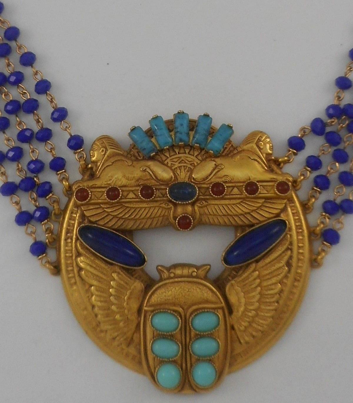 Spectacular signed Askew London 'Egyptian Revival' Medallion Necklace...showcasing antiqued Gold plated Brass medallion base decorated with Sphinxes and a winged Scarab, suspended from 5 rows of pinned 4mm blue glass Cushion shaped beads, finishing