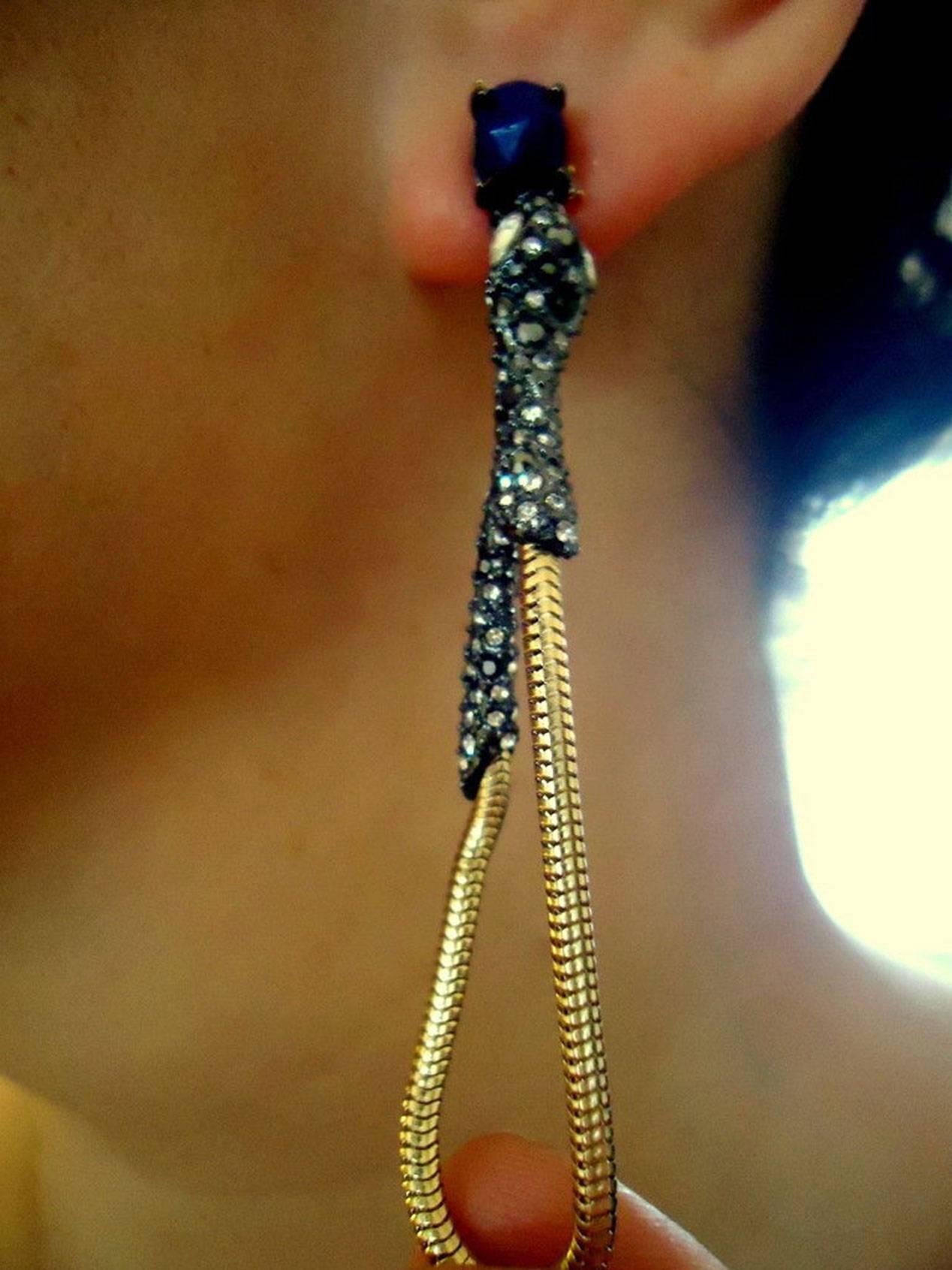 Exotic Snake Serpent earrings…So Sexy and Stunning dangling from the ears at a runway length of approx. 2 3/4”; the heads fully encrusted with sparkling black, grey and clear crystals followed by a hoop style gold gilt Snake chain. Signed AB for
