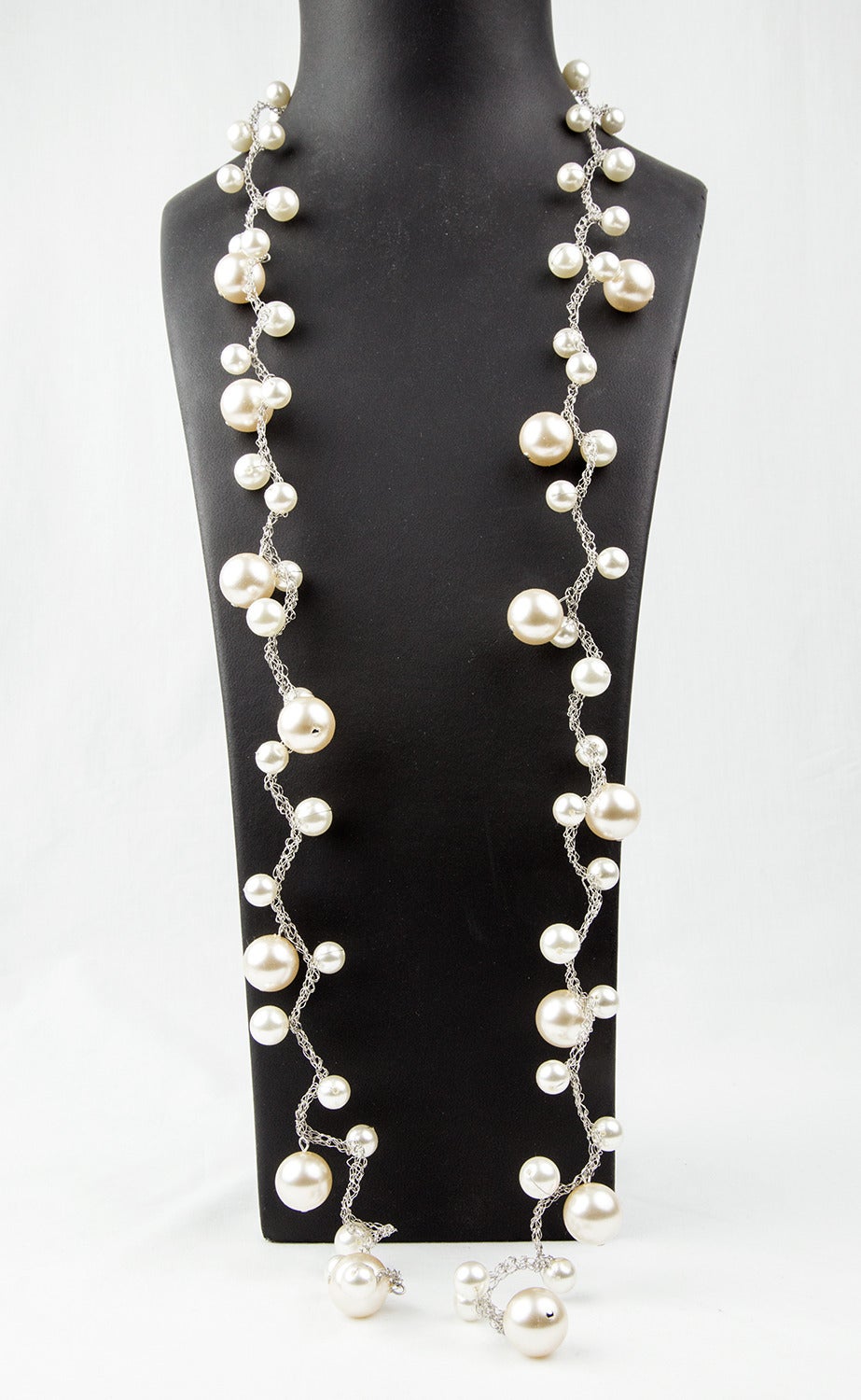 La magie des perles ! Long et élégant collier de fausses perles composé de fausses perles rondes graduées sur une chaîne en fil de fer tressé ; les perles mesurent environ 18 mm pour les grandes, 12 mm pour les moyennes et 10,5 mm pour les petites ;