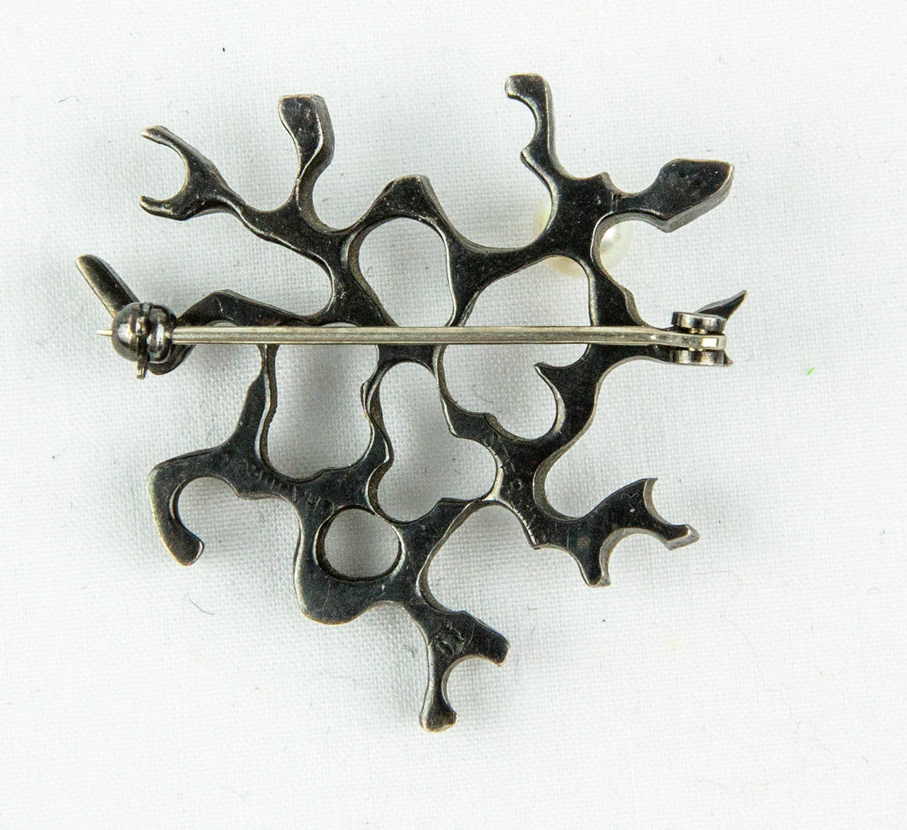 Pair of oxidized Sterling Silver Brooches featuring an open-work Biomorphic design and each Pin set with a Pearl.  Marked: CHAUDRON and artist’s trademark; approx. size: 1.5” x 1.5” and 1.5” x1”. A fantastic example of Canadian Bernard Chaudron; His