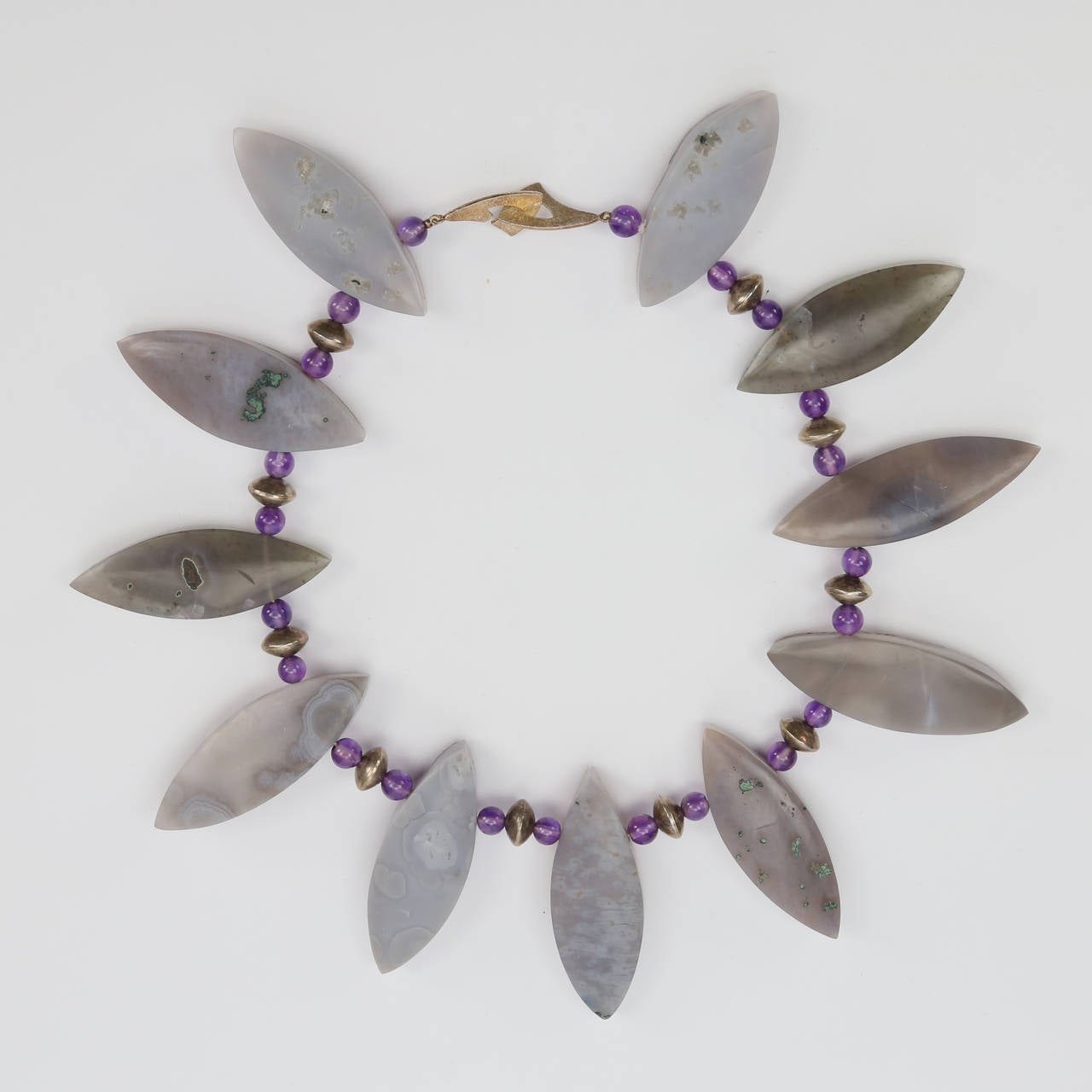 Con undici quarzi druzy ametista genuini e gemme naturali intervallati da perline rotonde di ametista e argento sterling; la collana è tenuta da una chiusura in argento sterling. Le pietre affusolate di quarzo ametista marquise sono lucidate sul