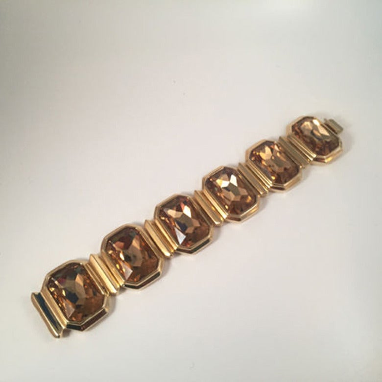 Large Avant Garde Amber Emerald Cut Swarovski Crystal Bracelet by Judith Leiber set with Six Large Swarovski Crystal Stones and Swarovski Crystal Accents. Gold-Plated Brass Setting, Invisible Push Lock Clasp. Approx. size: 7.5”-8