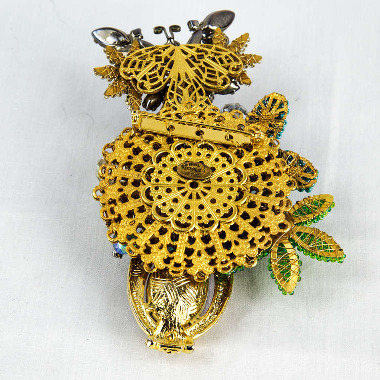 A Stunning signed STANLEY HAGLER N.Y.C. Large Brooch Pin, depicting a butterfly sitting on top of Flowers and featuring a very elaborate arrangement of faceted glass beads, pearl glass seed beads, rhinestones, moonstone beads; gold-tone metal and