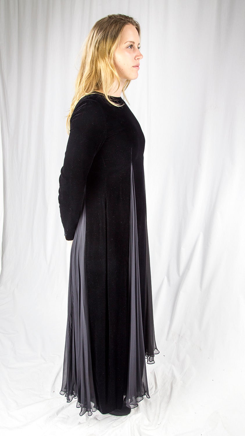 A Stunning Bill Blass Gown in Imported Black Velvet and flowing Charcoal Crepe de Chine Silk. Sleeves have button and loop closures at wrist. Hidden long back zipper. Body is silk lined. A luxurious simple style… Classic and Timeless! This vintage