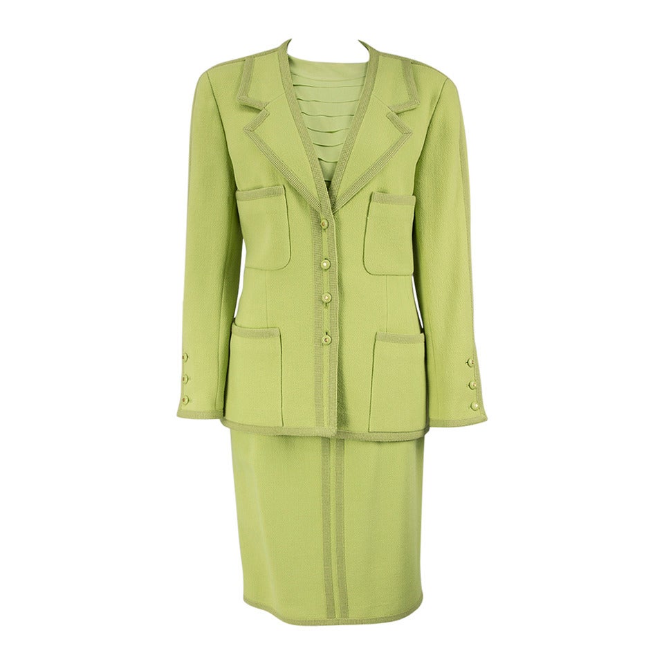 This Chic and Timeless suit features a Jacket Blazer single breasted buttoned front and four pockets, featuring grosgrain trim, buttons are decorated with the Chanel logo. The straight skirt has grosgrain trim, a back zipper and band, the Crepe de