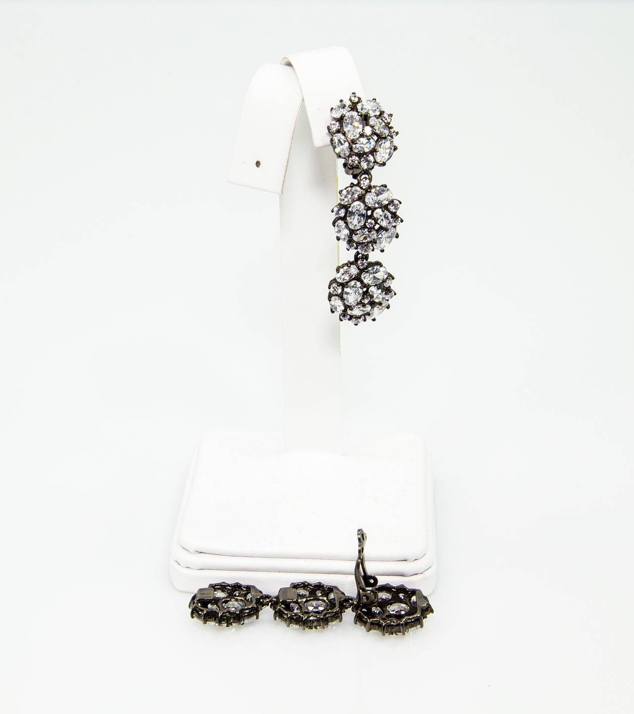 Beautiful Triple Round design Dangle Earrings, crafted in Black Rhodium plated sterling silver and encrusted with sparkling CZ; Earrings measures 2″ total length; Clip system; marked: 925. Chic, Classic and Timeless!