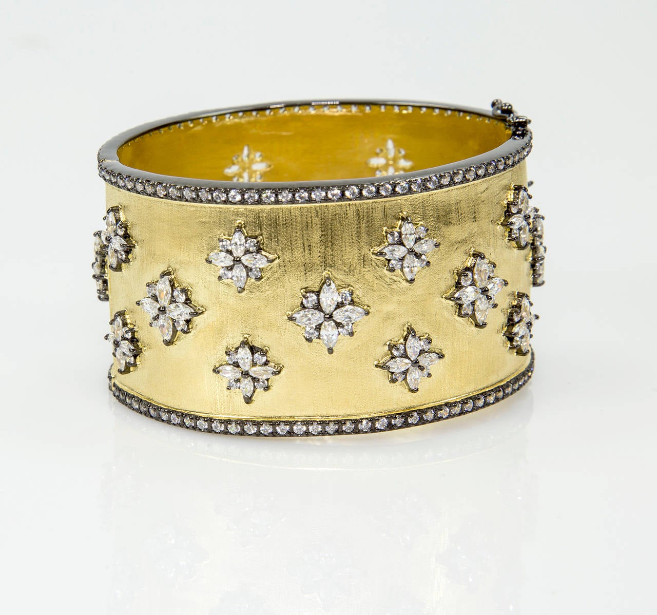 Gorgeous Textured Gilt Silver Cuff Bangle Bracelet studded with CZ in black rhodium snowflake designs and black rhodium CZ encrusted outer borders. Push clasp and double ‘8’ safety. Marked: 925. Fits average wrist size. Interior measurements: 2.25”