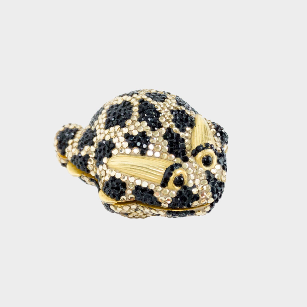 Featuring an Adorable Frog encrusted with clear and black Swarovski Crystals. Signed and dated: Judith Leiber 1981. Pillbox measures approx. 2.25” x 1.75”. Perfect for collectors and animal lovers alike!