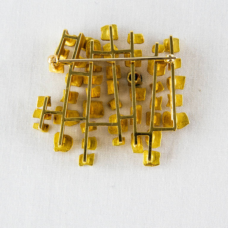 Dynamic Abstract 18K yellow gold Pin set with one facet cut tourmaline inspired by Habitat 67, all handmade in 18K yellow gold, by Walter Schluep; Marked: 18K SCHLUEP; One-of-a-Kind; measuring approx. 1.75” x 1.5”; C1967. 

Habitat ’67…The Origin: