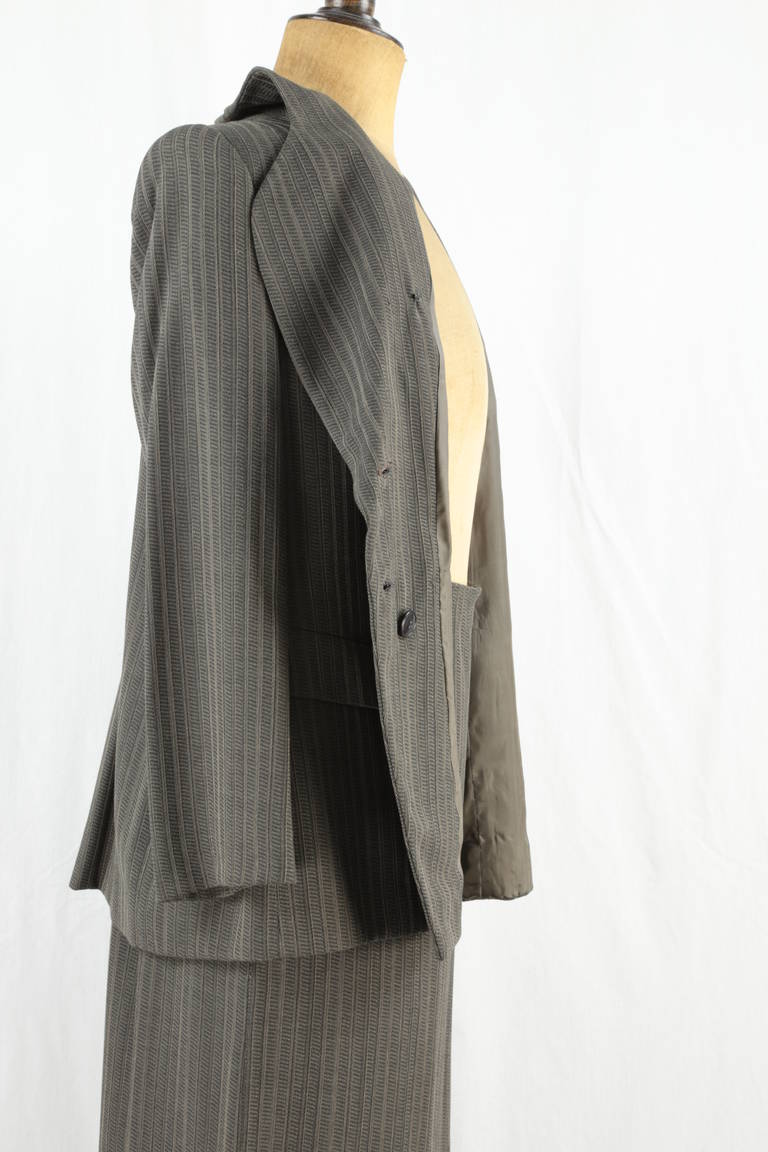 The suit by Giorgio Armani features a Jacket long and Skirt, in subtle hues of gray and taupe, combining, the masculine and the feminine as only the master, Giorgio Armani can do! c1993.