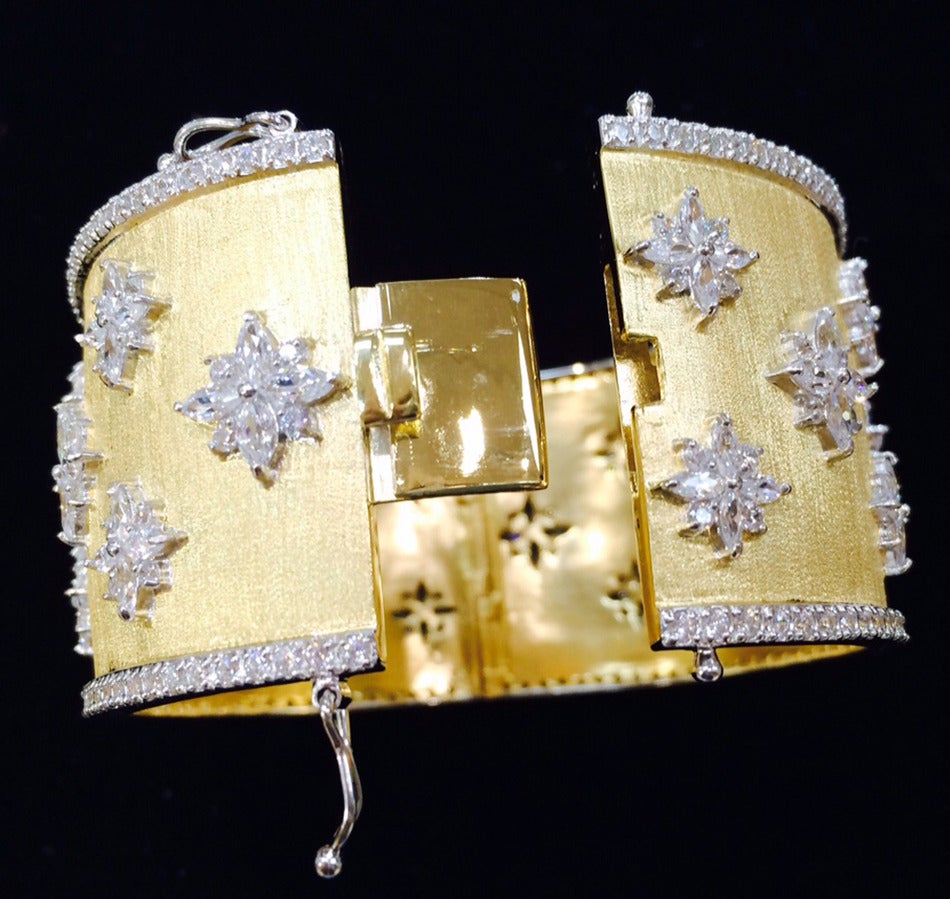 Gorgeous Textured Gilt Silver Cuff Bangle Bracelet studded with CZ snowflake designs; white gold plated CZ encrusted outer borders. Push clasp and double ‘8’ safety. Marked: 925. Fits average wrist size. Interior measurements: 2.25” x 2”; bangle