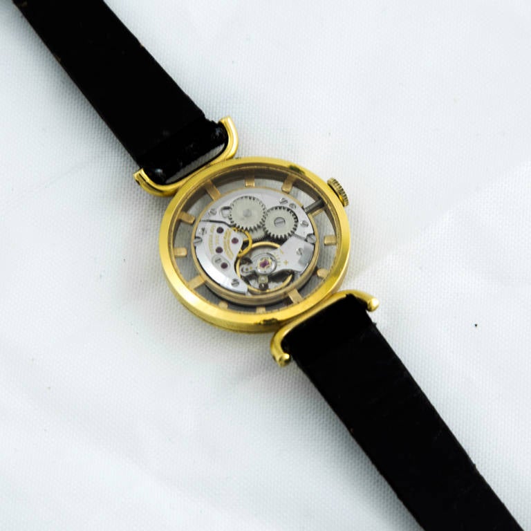 Hard to find JUVENIA Ladies Mystery Dial Wristwatch; Swiss 17 jewel movement, featuring a skeleton view of the mechanism through the back crystal; front view shows the hands in red through a see through section that has numeral markers so you can