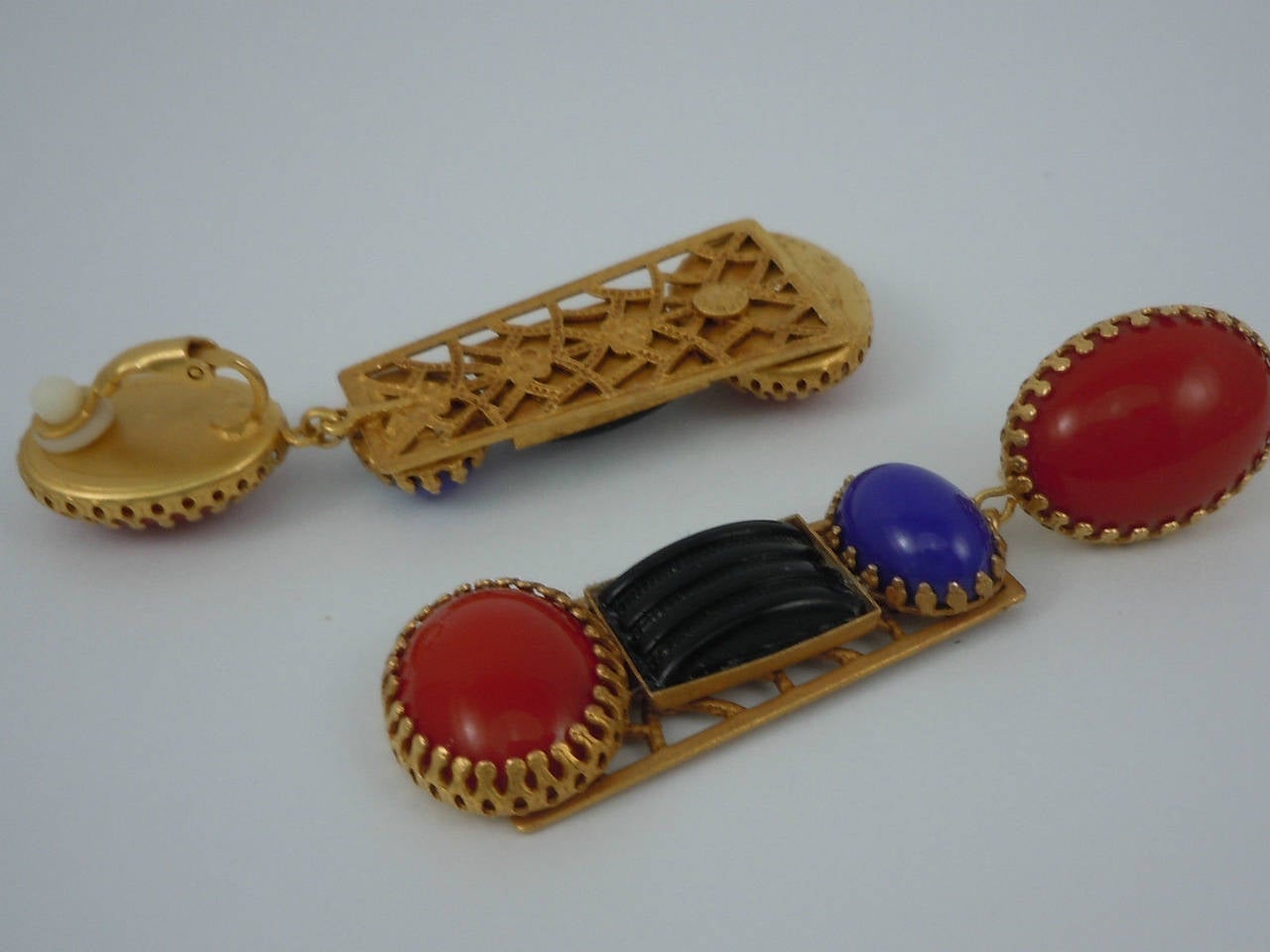 Featuring signed Askew London Antiqued Gold plated Filigree bases decorated with vintage Ridged Black Glass rectangles, Red and Blue Glass Cabochons with clip on tops decorated with large Red Glass Cabochons; each earring measures approx. 2.90'' x