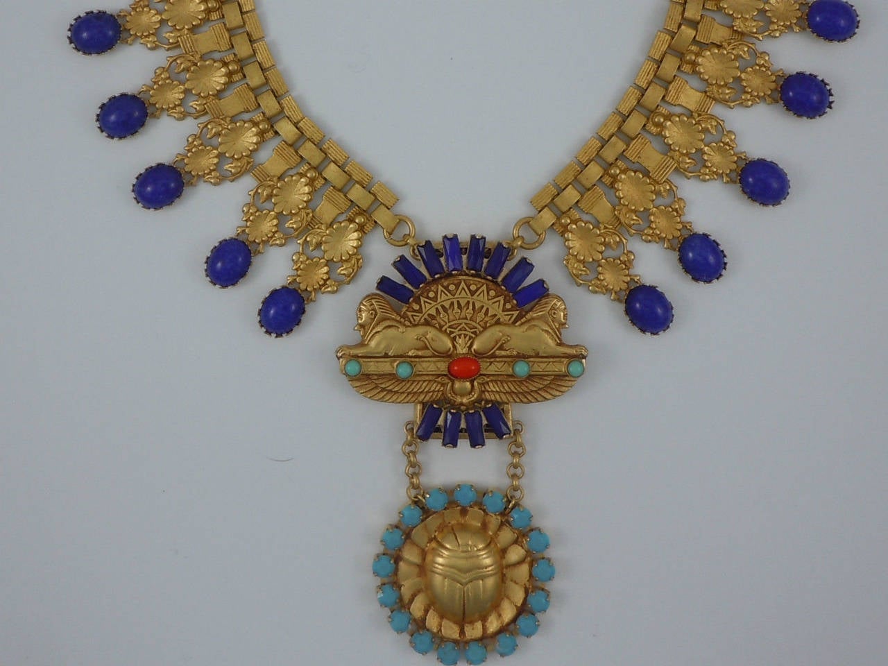 Featuring a Stunning 'Egyptian Revival' Double Sphinx Runway Necklace by Askew London; Antiqued Gilt brass Double Sphinx with glass baguette and cabochon stone decoration. The Sphinx are flanked by lengths of flat chain decoration with Gilt brass