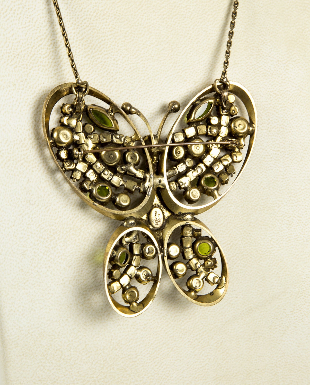 Featuring a Beautiful Butterfly Necklace, also made to be worn as a Brooch, encrusted with faceted Purple, Pink and Green Glass stones; a showy delight of color and contrasts; center set with an oval cabochon stone, incorporating these wonderful