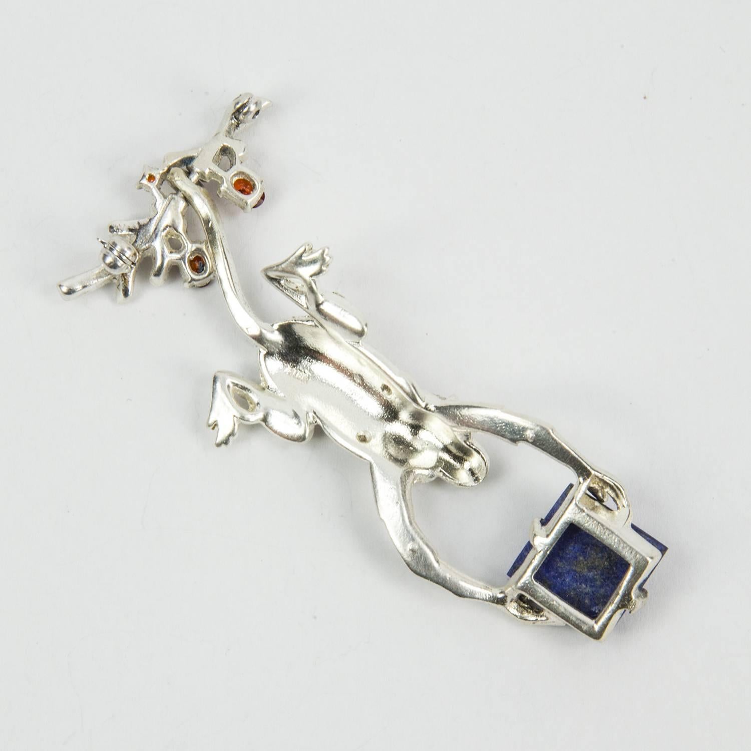 Rare beauty! Adorable Monkey holding a genuine Sugarloaf Lapis Lazuli gently swinging by his tail from the adorned branch pin, body set with sparkling CZ
rhinestones. Finely crafted in Sterling Silver; measuring approx. 2.75” long. Add a little