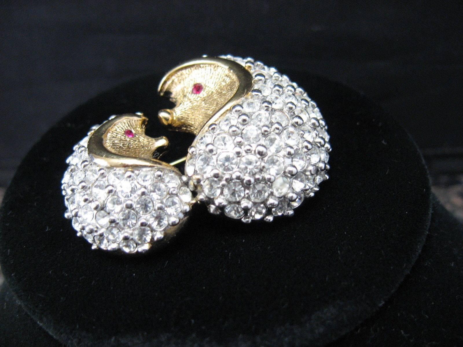 Showcasing a Darling Mama and Baby Hedgehog pin set pave with sparkling Faux Diamond Crystals in a gold tone setting; by Attwood & Sawyer England; Signed A&S; appox. 1.75