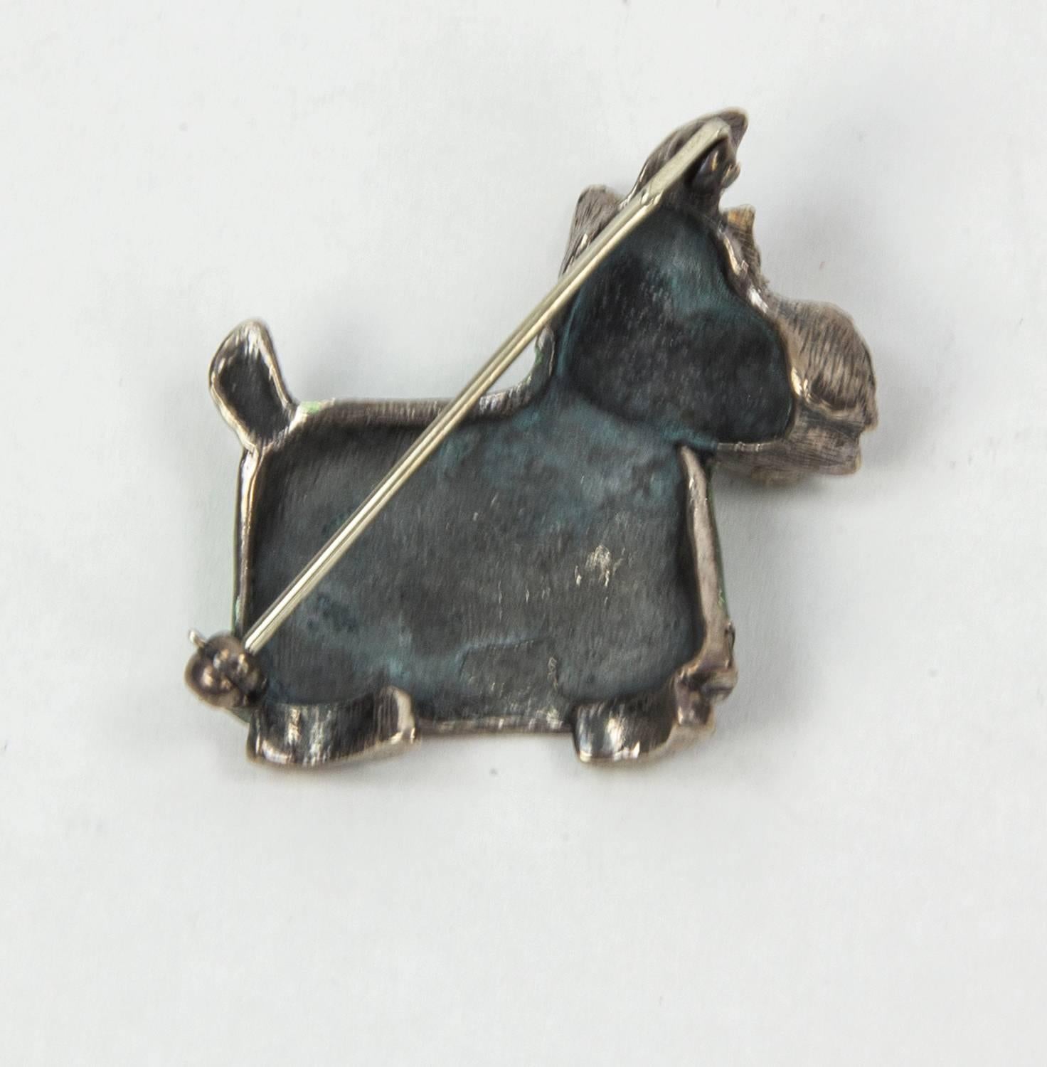 Adorable Scottish terrier in Sterling Silver, sporting a Beautiful green enamel coat; measures approx. 1.25” x 1.25”. The go-to accessory, offering Timeless appeal and will be a cherished addition to your collection! 
