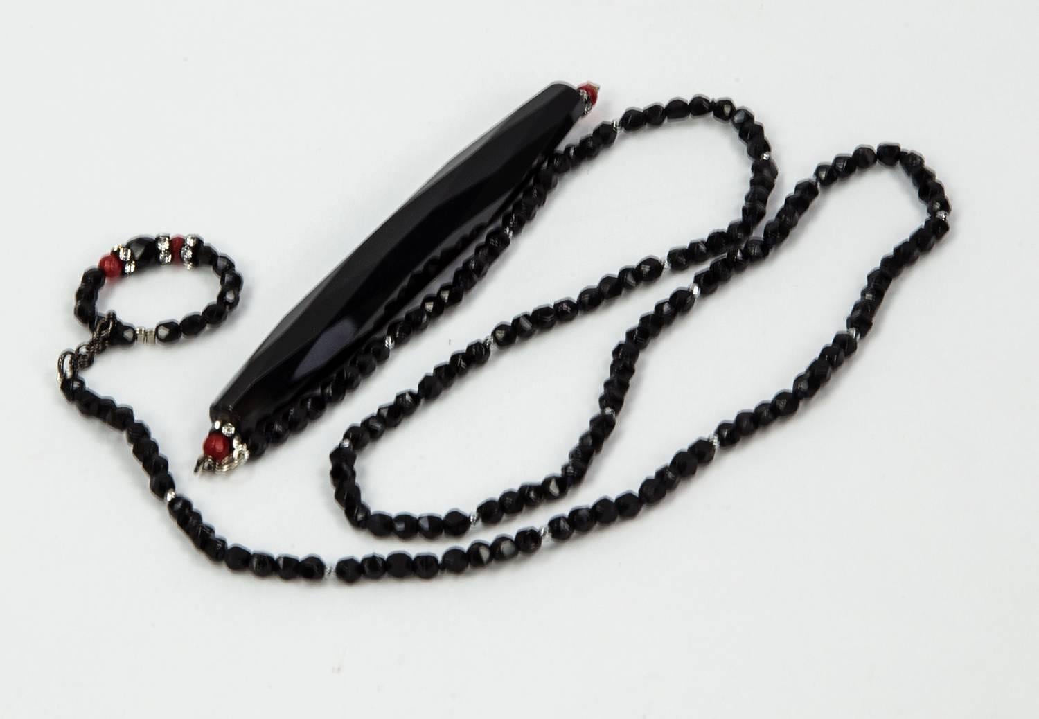 Soft faceted sheen Black Jet Lariat Necklace, accented by faceted red, silver and sparkling CZ stones, suspending a large faceted elongated teardrop shaped Jet glass bead, measuring approx. 4” in length; approx. length of necklace: 30”. Chic and