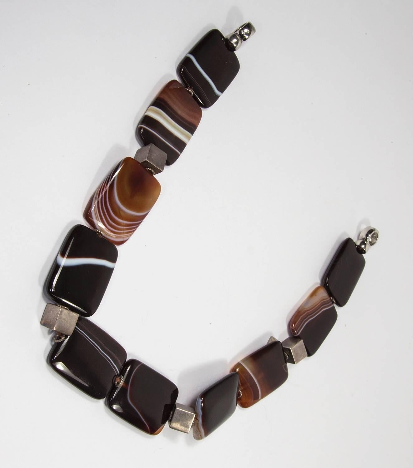 Beautifully designed large banded rectangular agate beads necklace inter spaced with sterling silver cubes and S/S clasp; agates are approx. 30.5mm x 40mm each; display beautiful colors ranging from chocolate to white to black on a waved, close