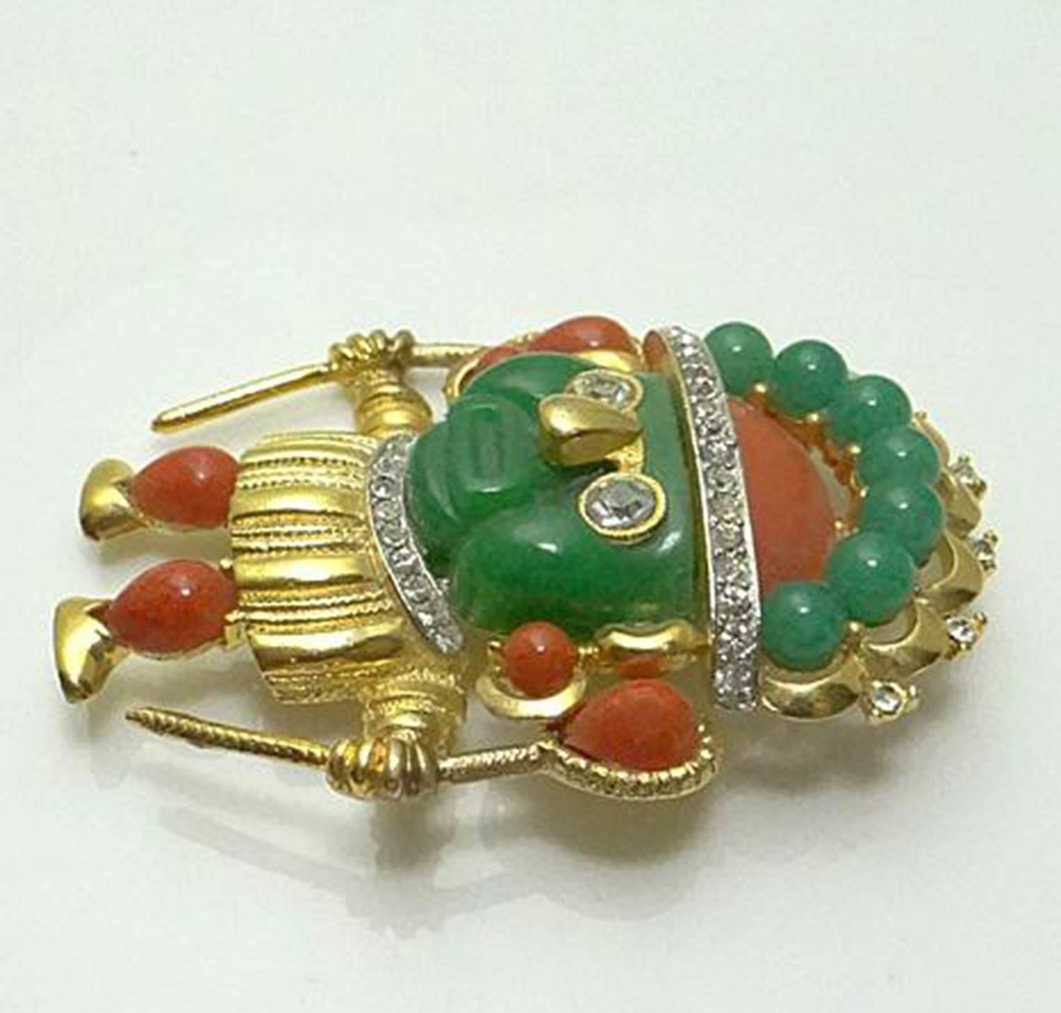 Signed Hattie Carnegie figural pin, depicting an Aztec Warrior adorned with CZ rhinestones, colorful green and orange Lucite stones. The pin measures 2.25” X 1.63”. C1960s. Highly collectible! Fabulous and Timeless as you are… Illuminating your Look
